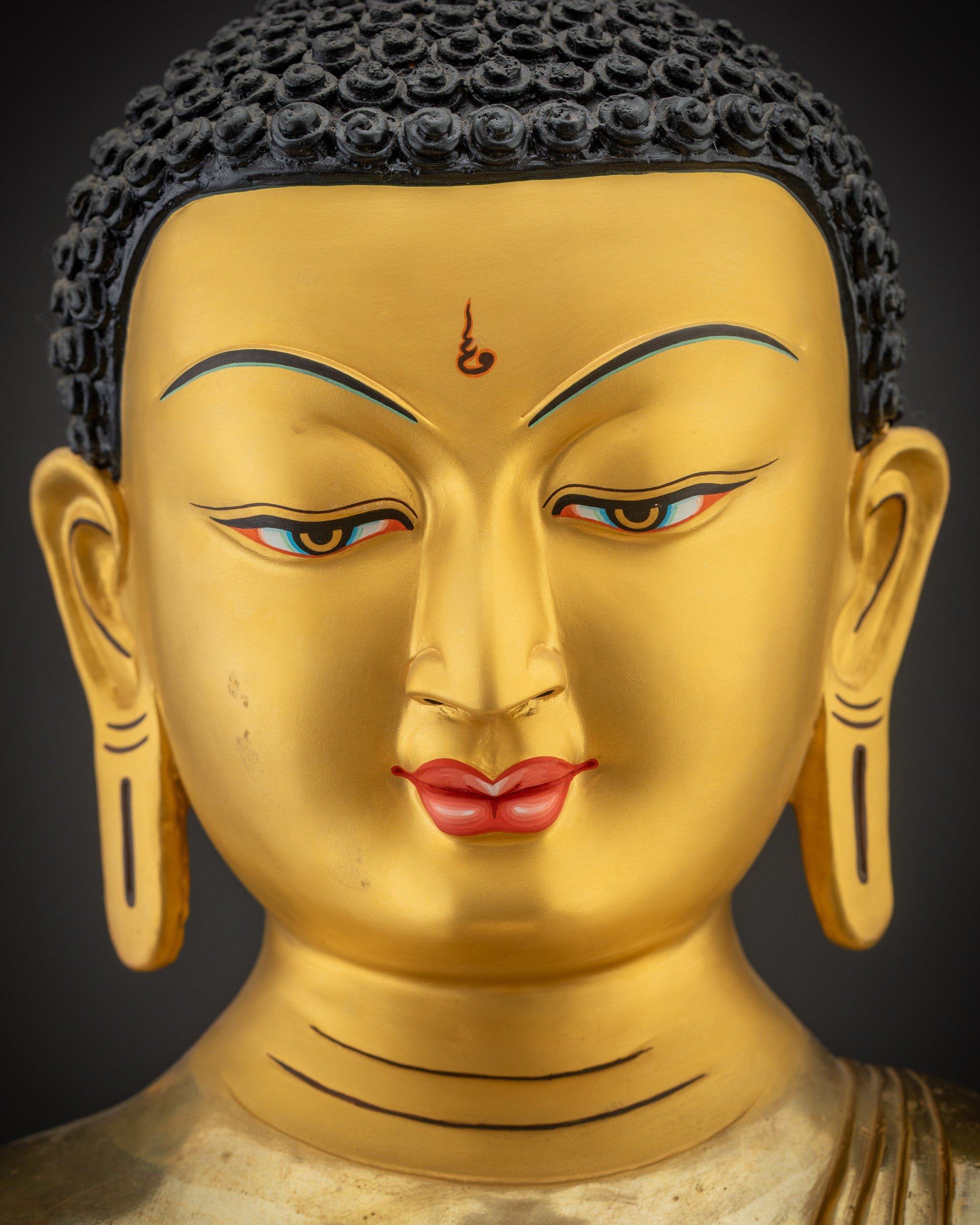Detailed close up of Shakyamuni Buddha face gold gilded Nepalese Buddhist statue