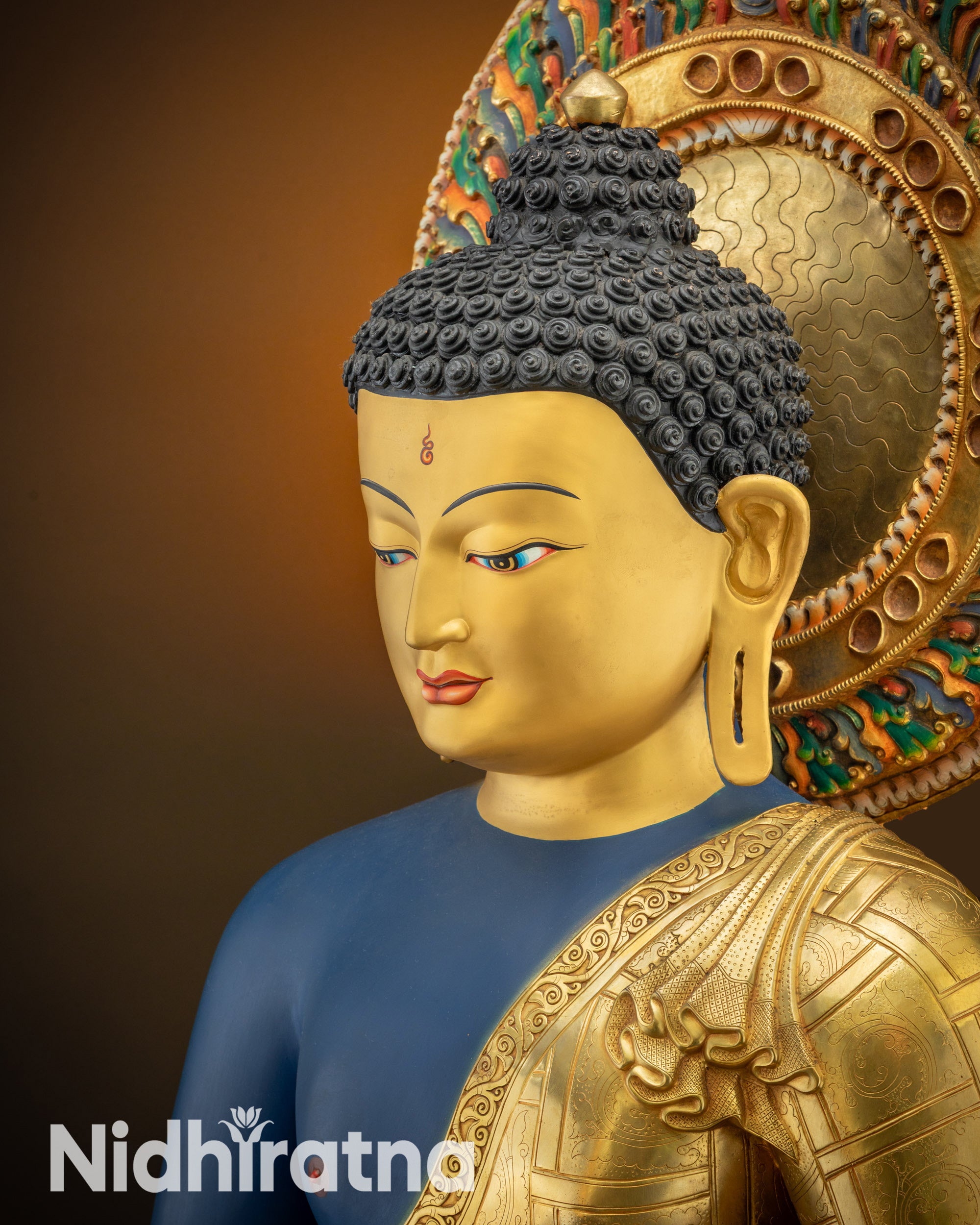 Detailed close up of upper face showing serene eyes and gold-gilded features of Medicine Buddha