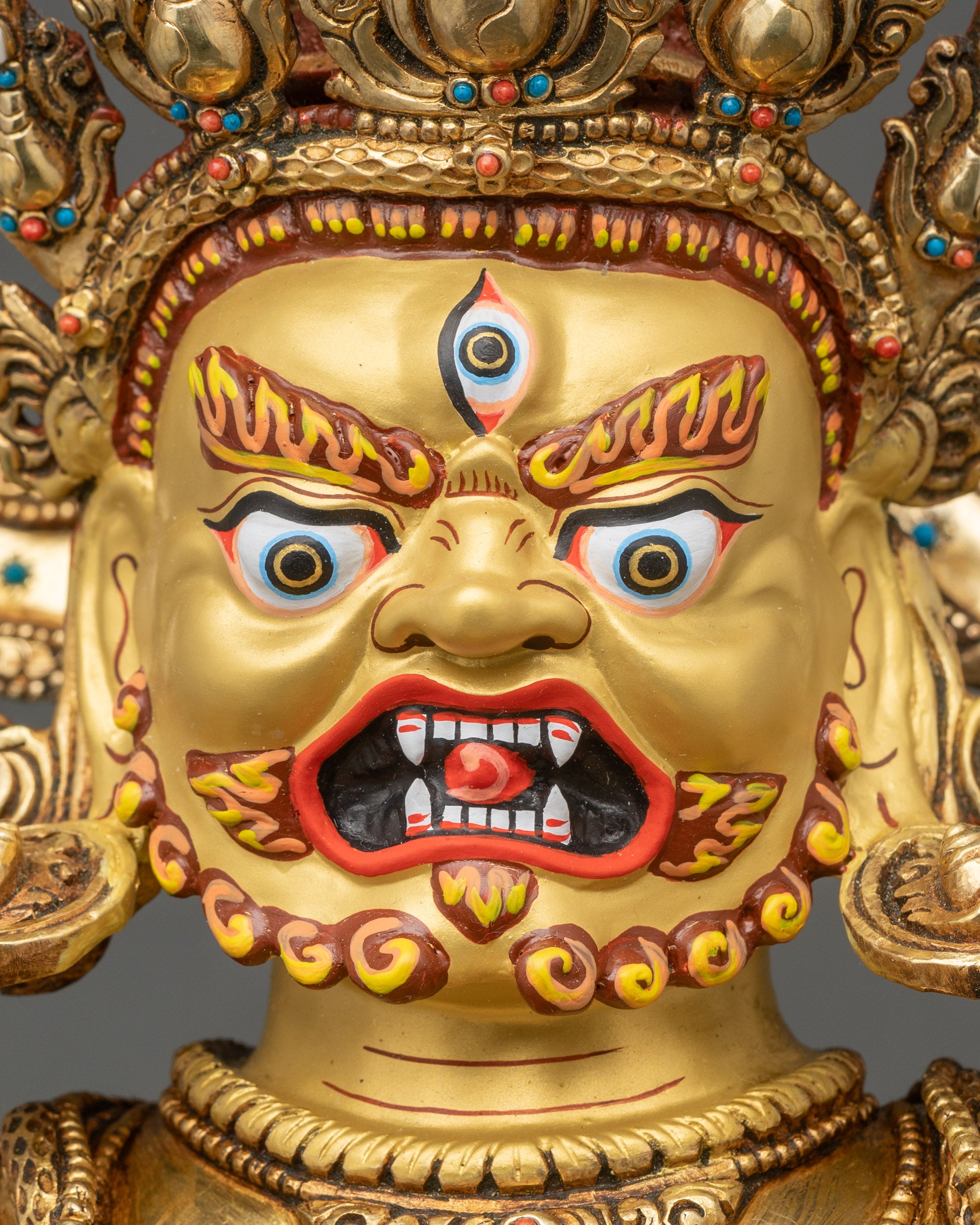 Detailed face close-up of Black Dzambhala, gold-painted with third eye and wrathful expression