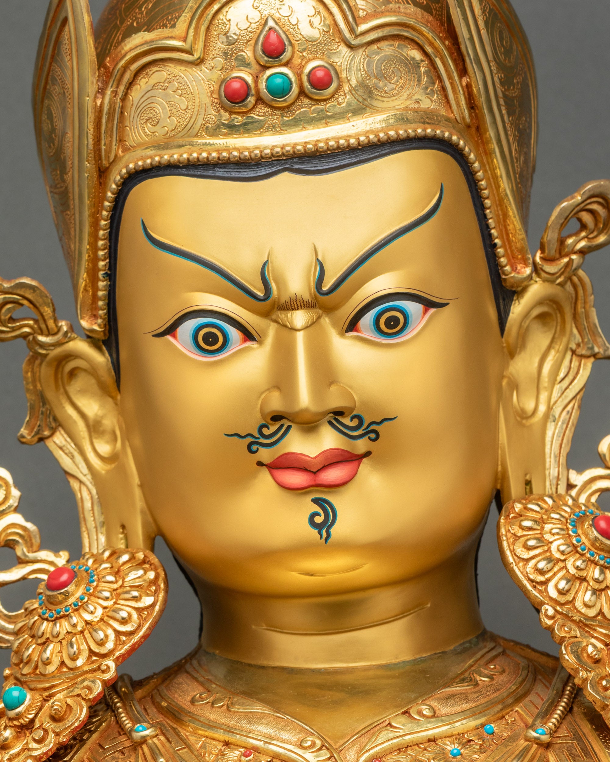 Detailed face close-up of Guru Rinpoche statue, hand-painted semi-wrathful expression, gold-painted face, handcrafted Nepal