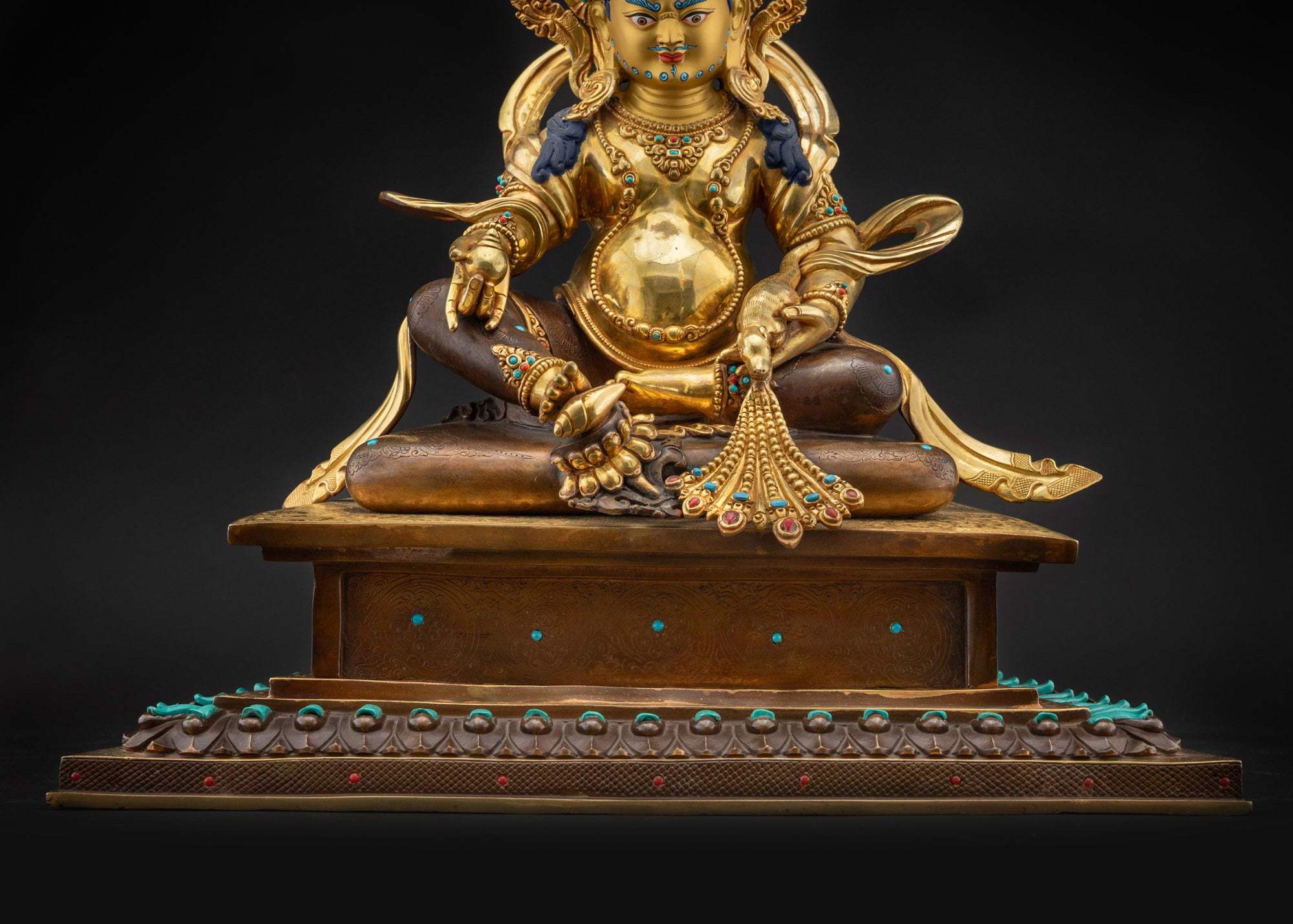 Detailed landscape front shot Dzambhala statue on lotus seat with halo and gemstones