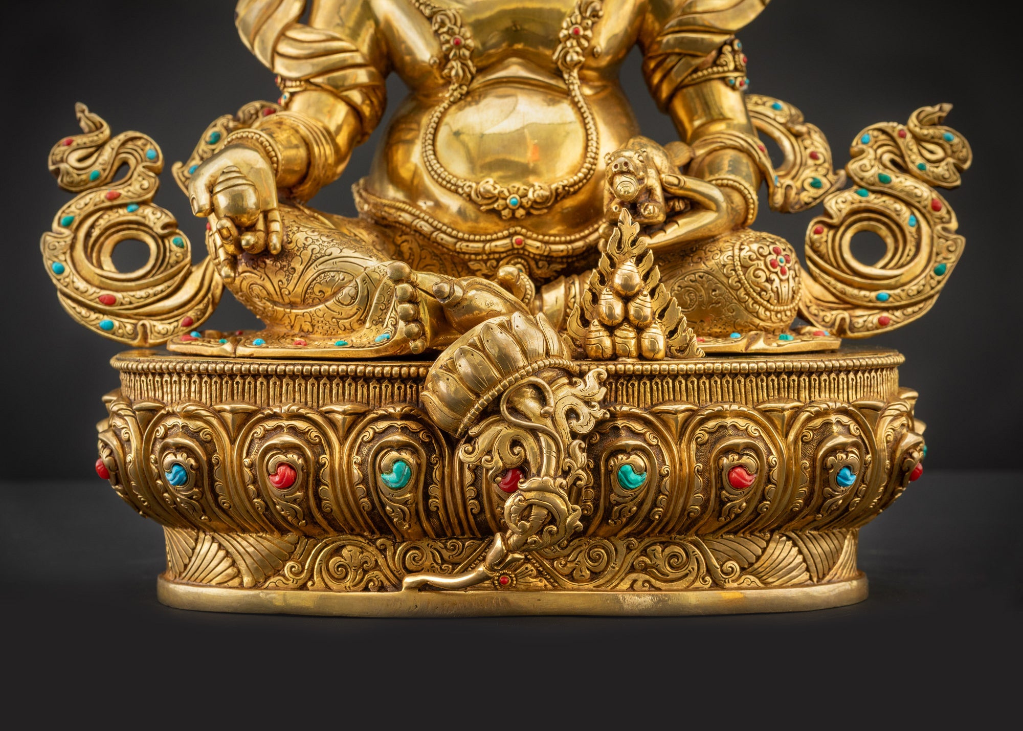 Detailed landscape front view of statue seated on lotus showing gold-gilded features