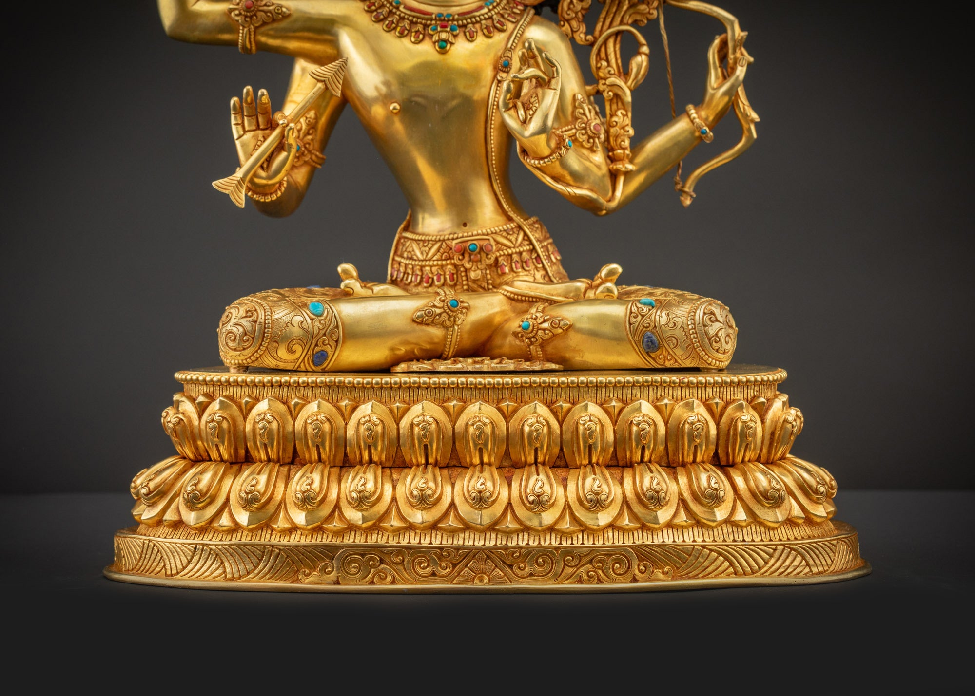 Detailed landscape shot front view of Maha Manjushri statue on lotus seat with shining gold details.