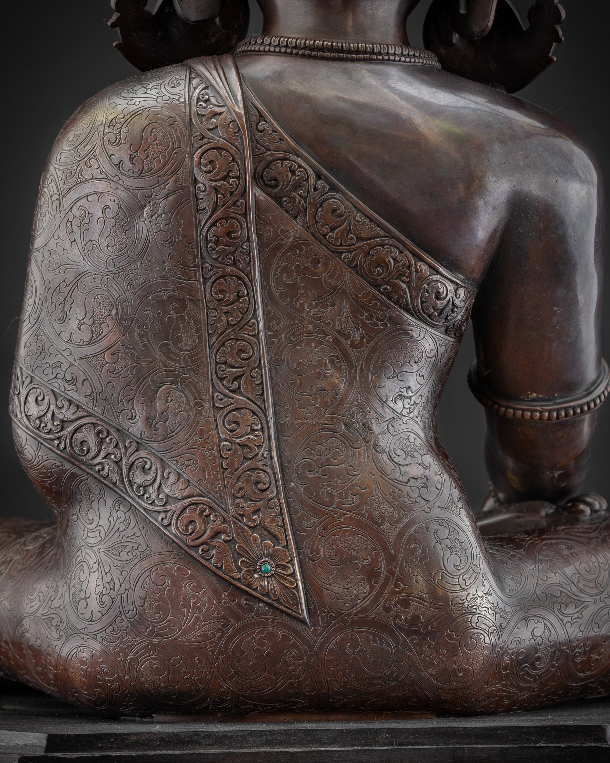 Detailed shot carved Buddhist monk’s robe on oxidized Shakyamuni Buddha artwork