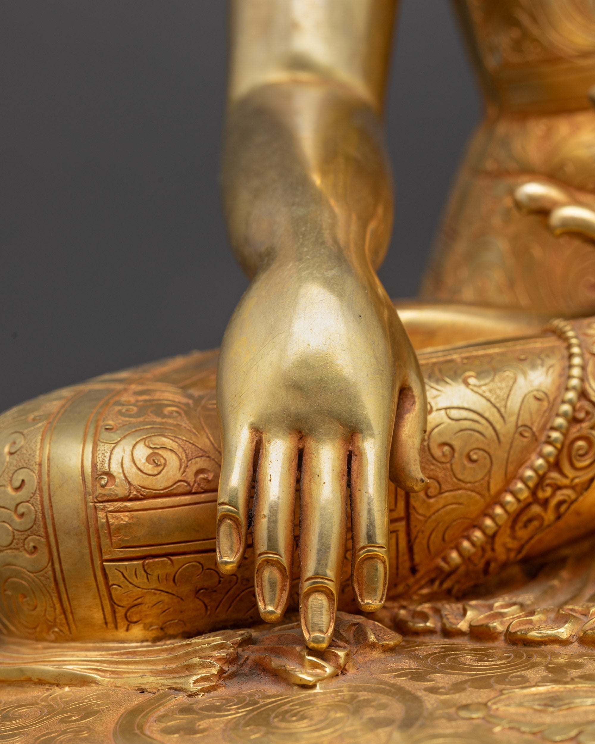Detailed shot of Buddha earth-touching mudra hand on lotus base, symbolizing awakening
