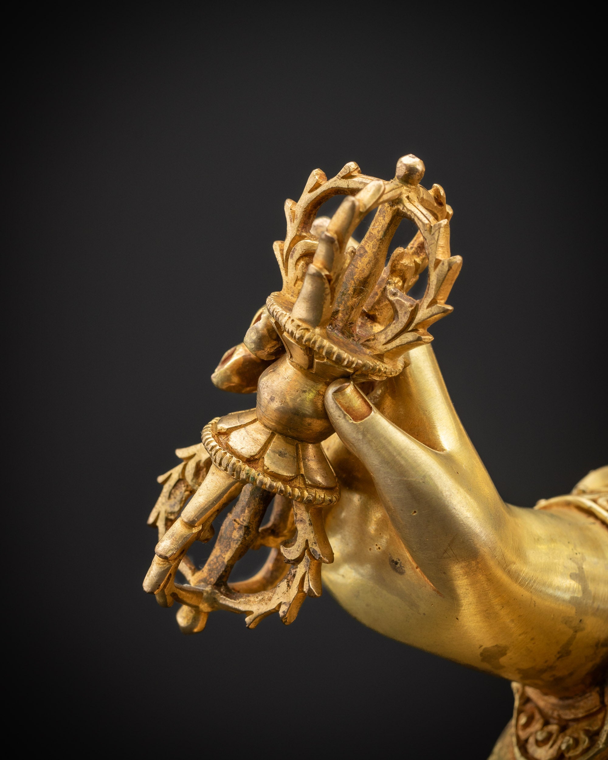 Detailed shot of Guru Rinpoche holding vajra symbolizing indestructible wisdom