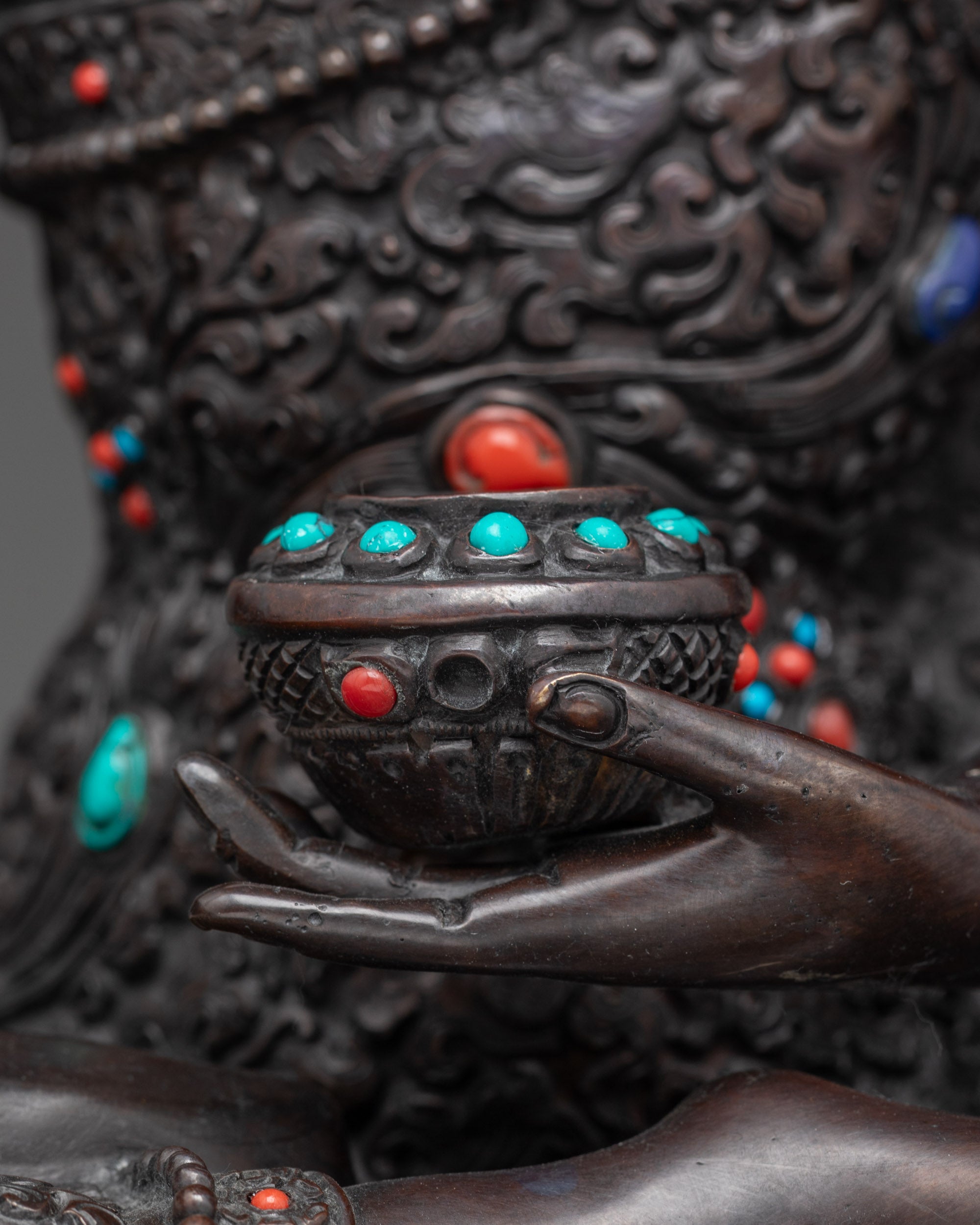 Detailed shot of alms bowl Buddha Shakyamuni oxidized statue in meditation pose