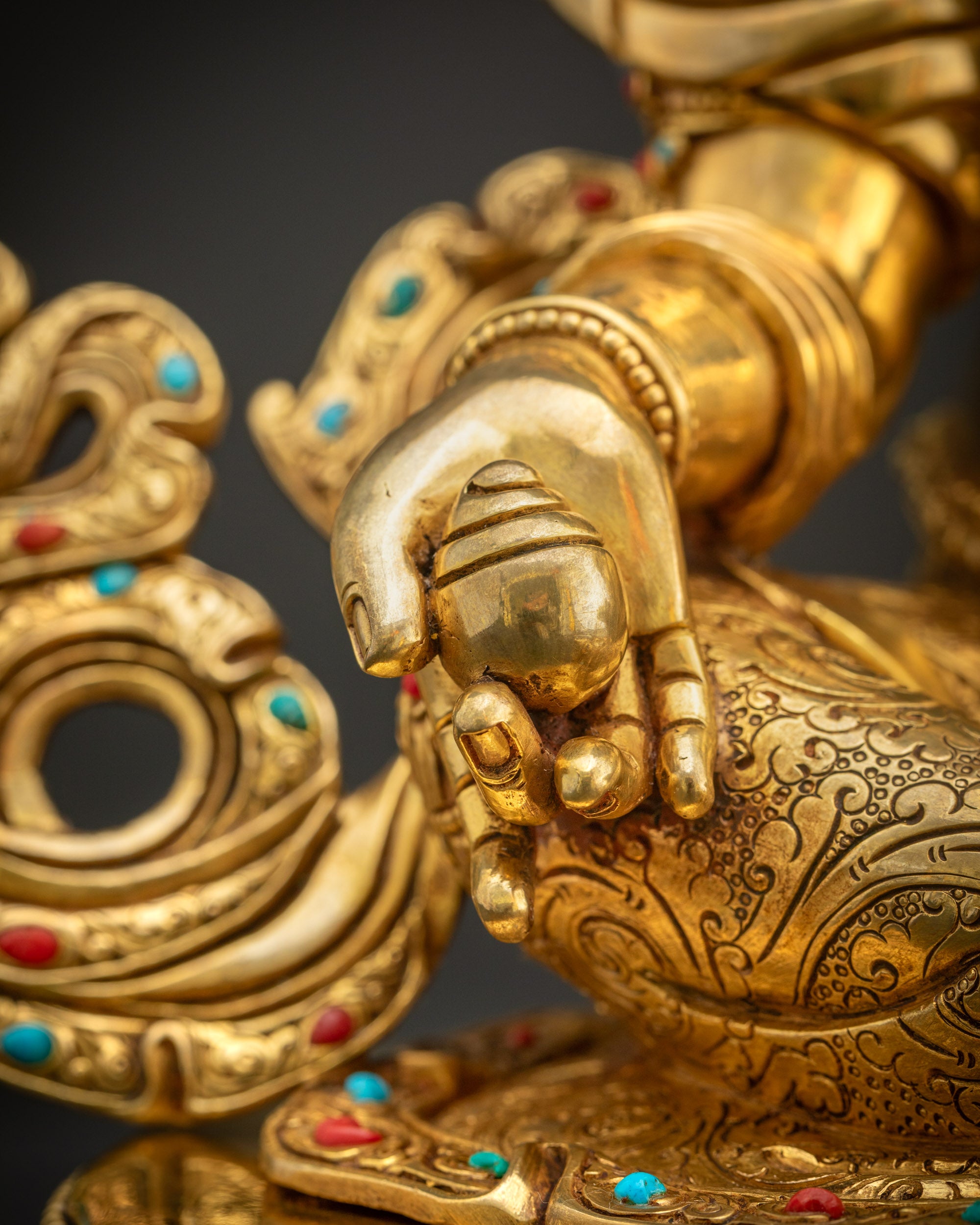 Detailed shot of citron fruit held by Dzambhala statue showing gold detailing