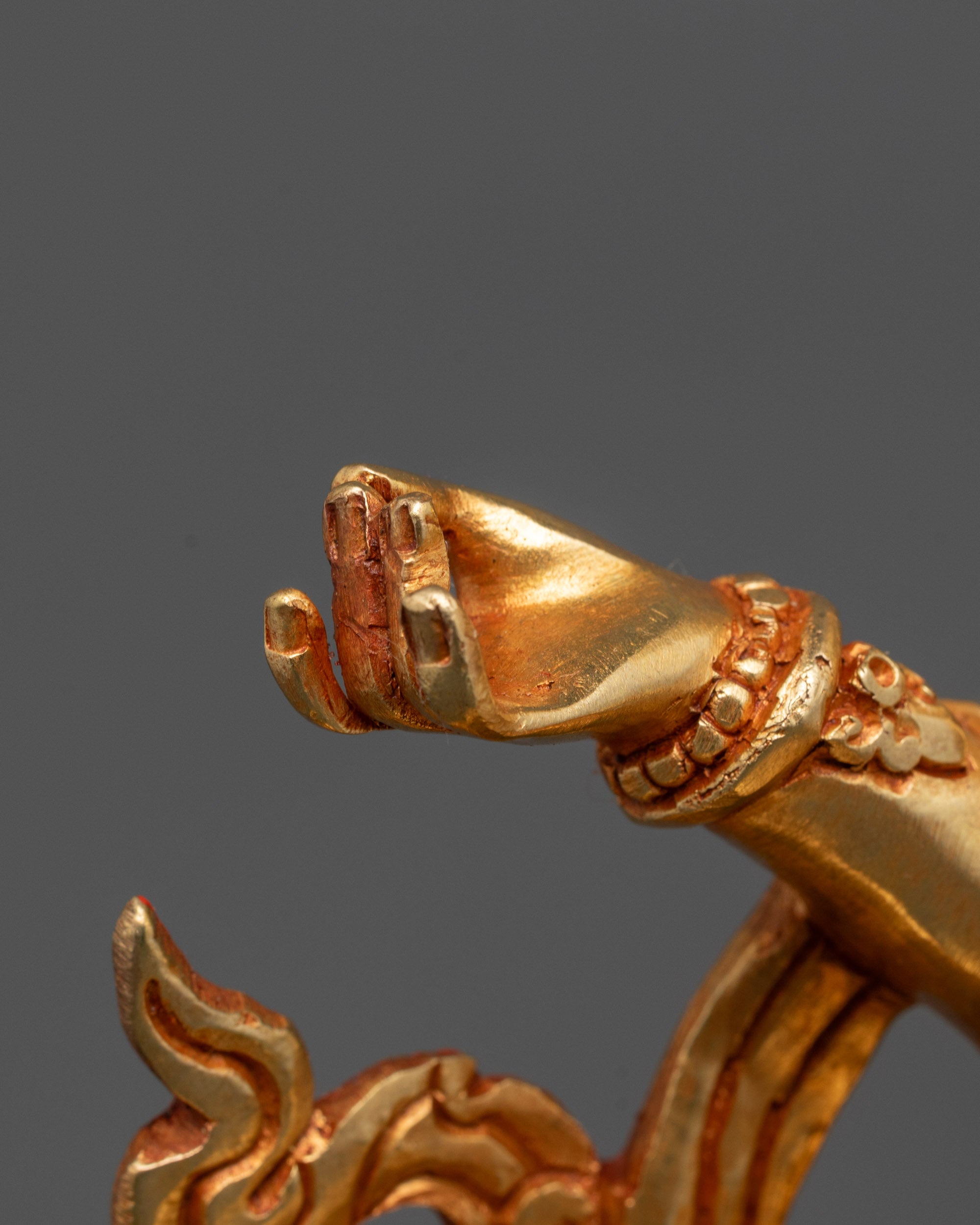 Detailed shot of gold-gilded Samantabhadra face and copper body with utpala flower