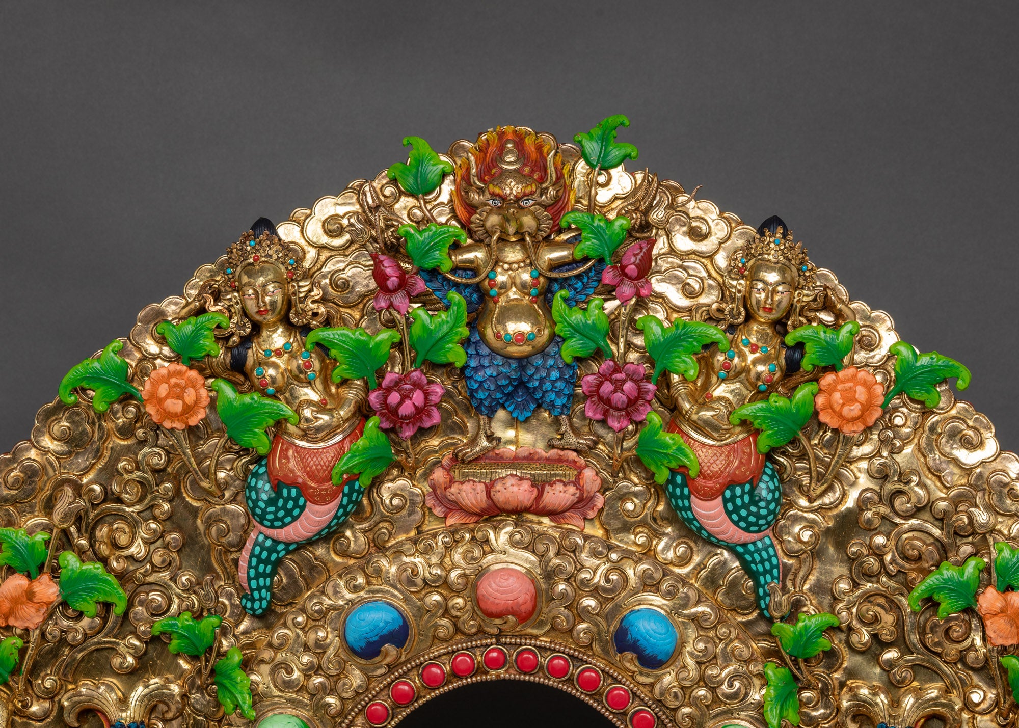 Detailed shot of miniature Garuda and celestial figures on throne base