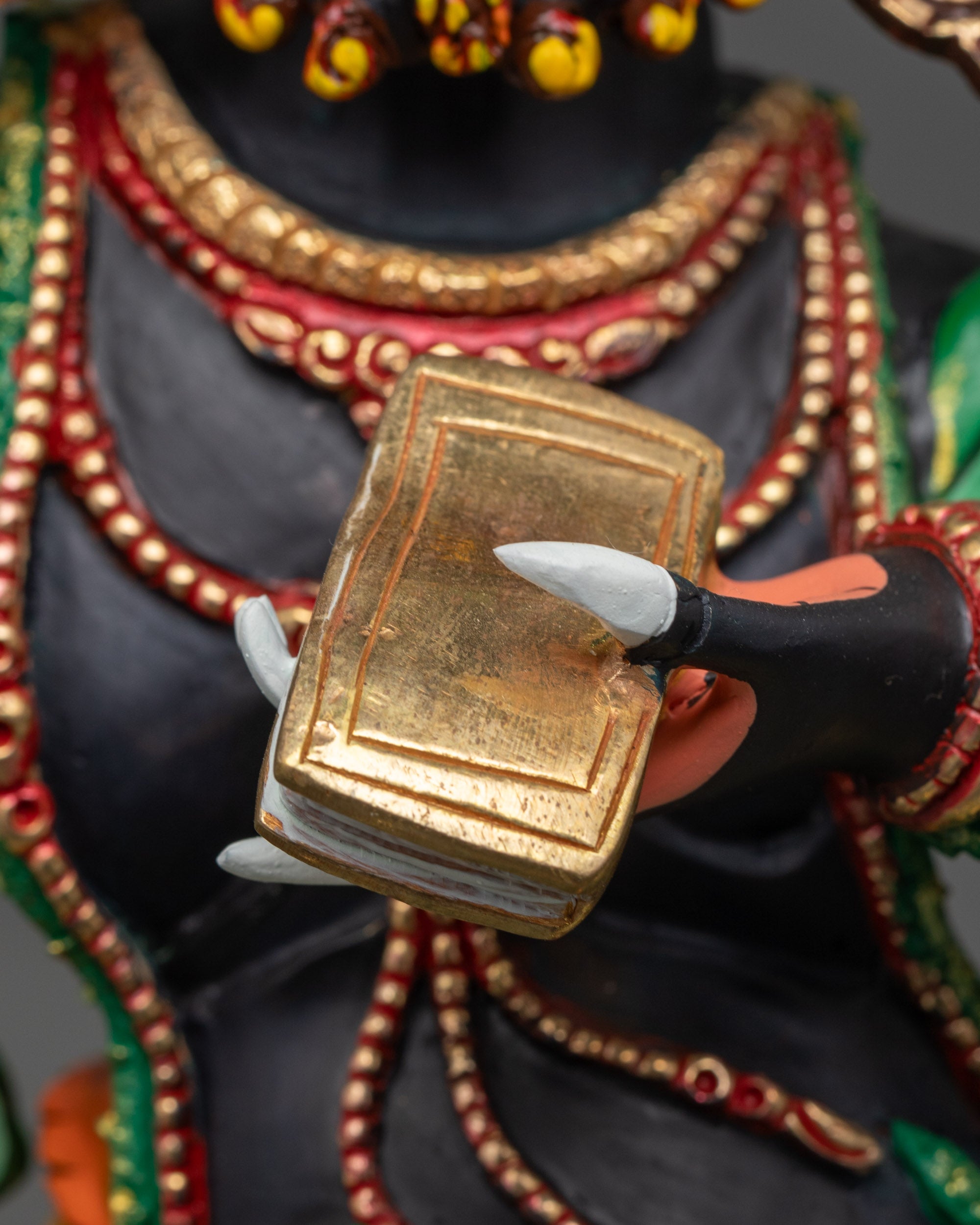 Detailed shot of third eye face, five-skull crown, and black copper body