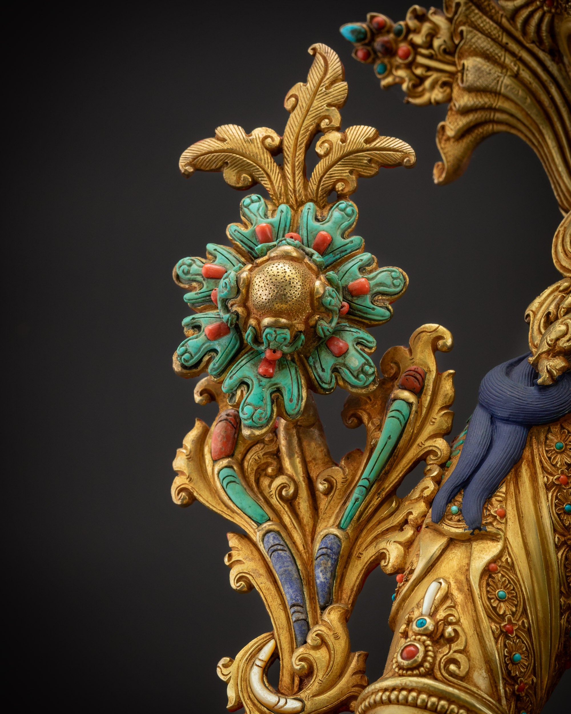 Detailed shot of utpala flower on Green Tara altar statue with gilded highlights