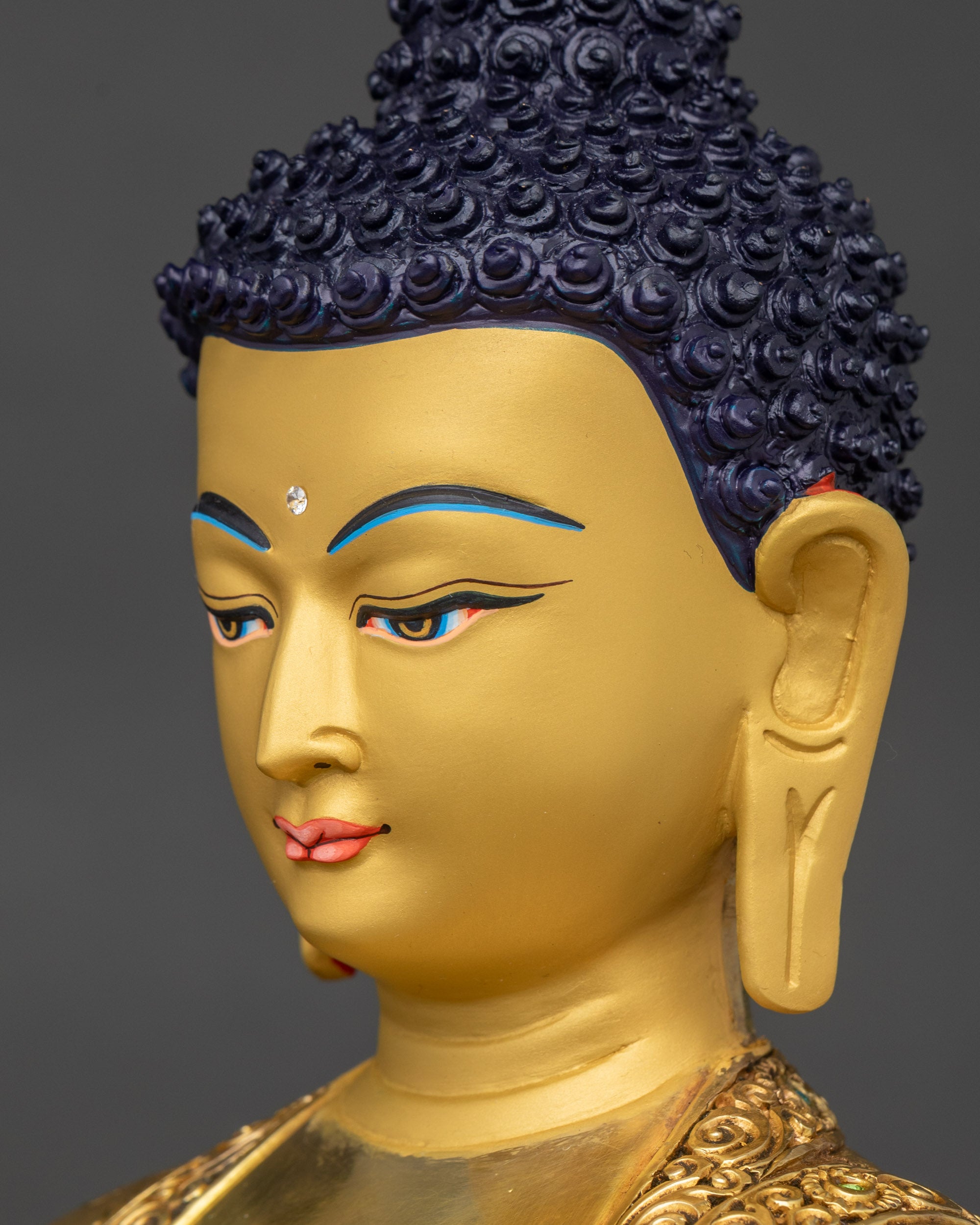 Detailed side close-up face of Shakyamuni Buddha, gold finish and deep blue eyes