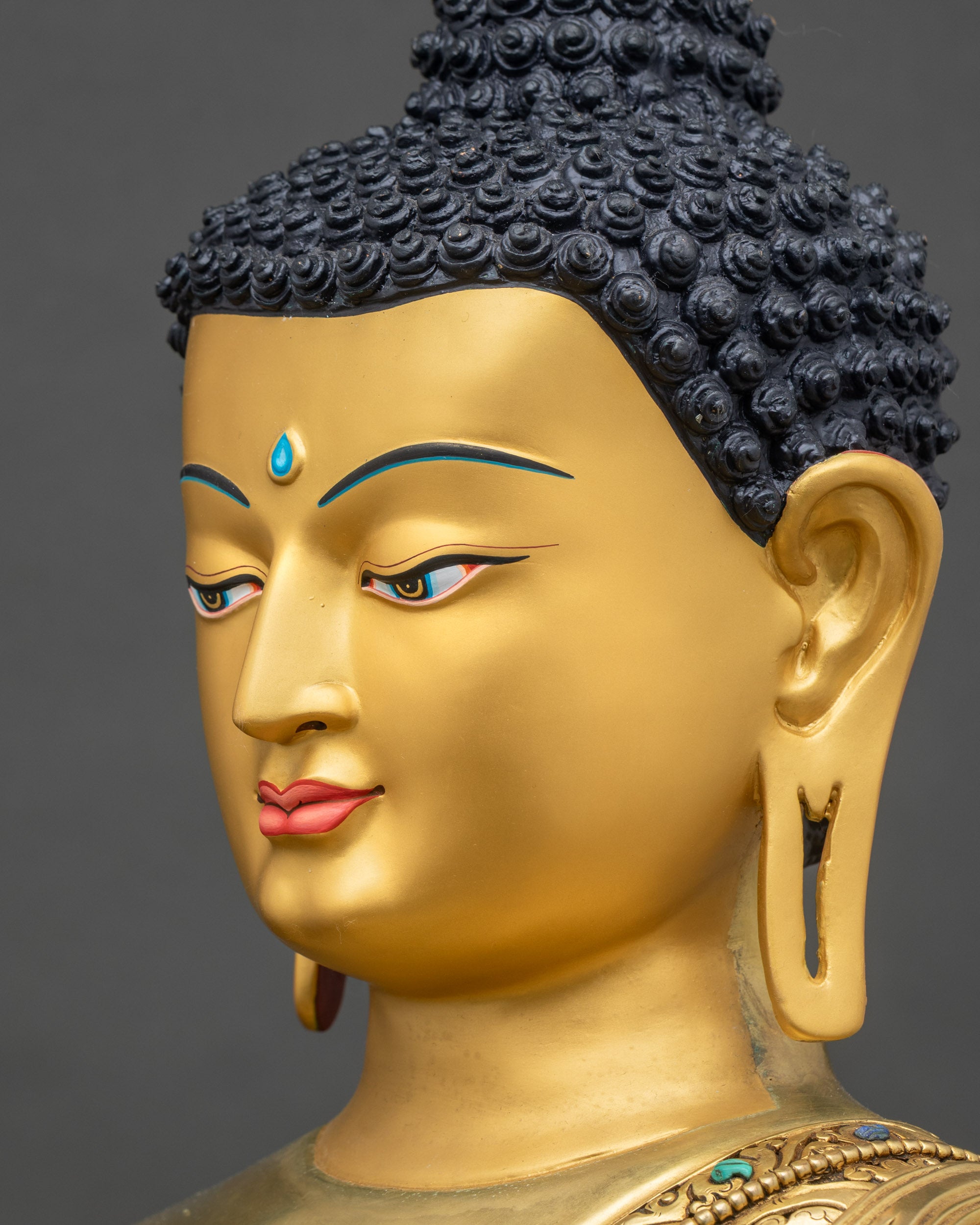 Detailed side close-up of Buddha face, gold-painted features and serene meditation expression