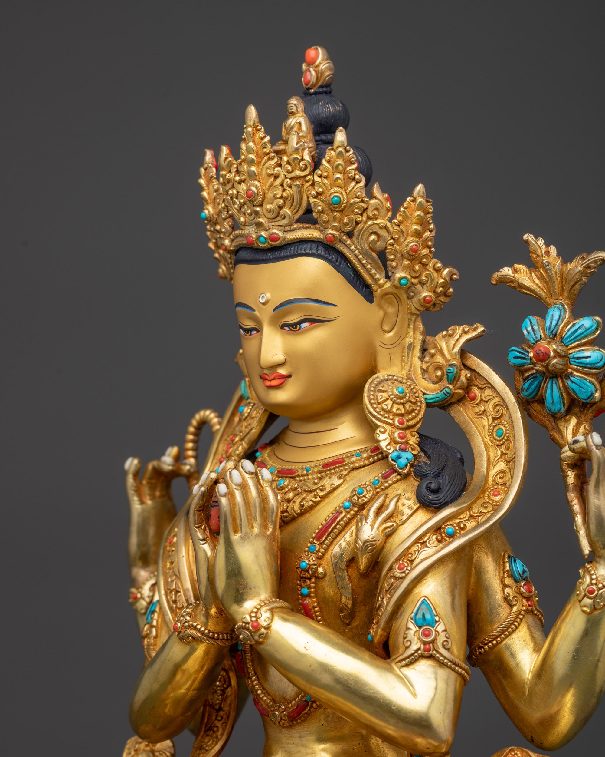 Detailed side close-up of Chenrezig statue showing golden facial features and sacred attributes