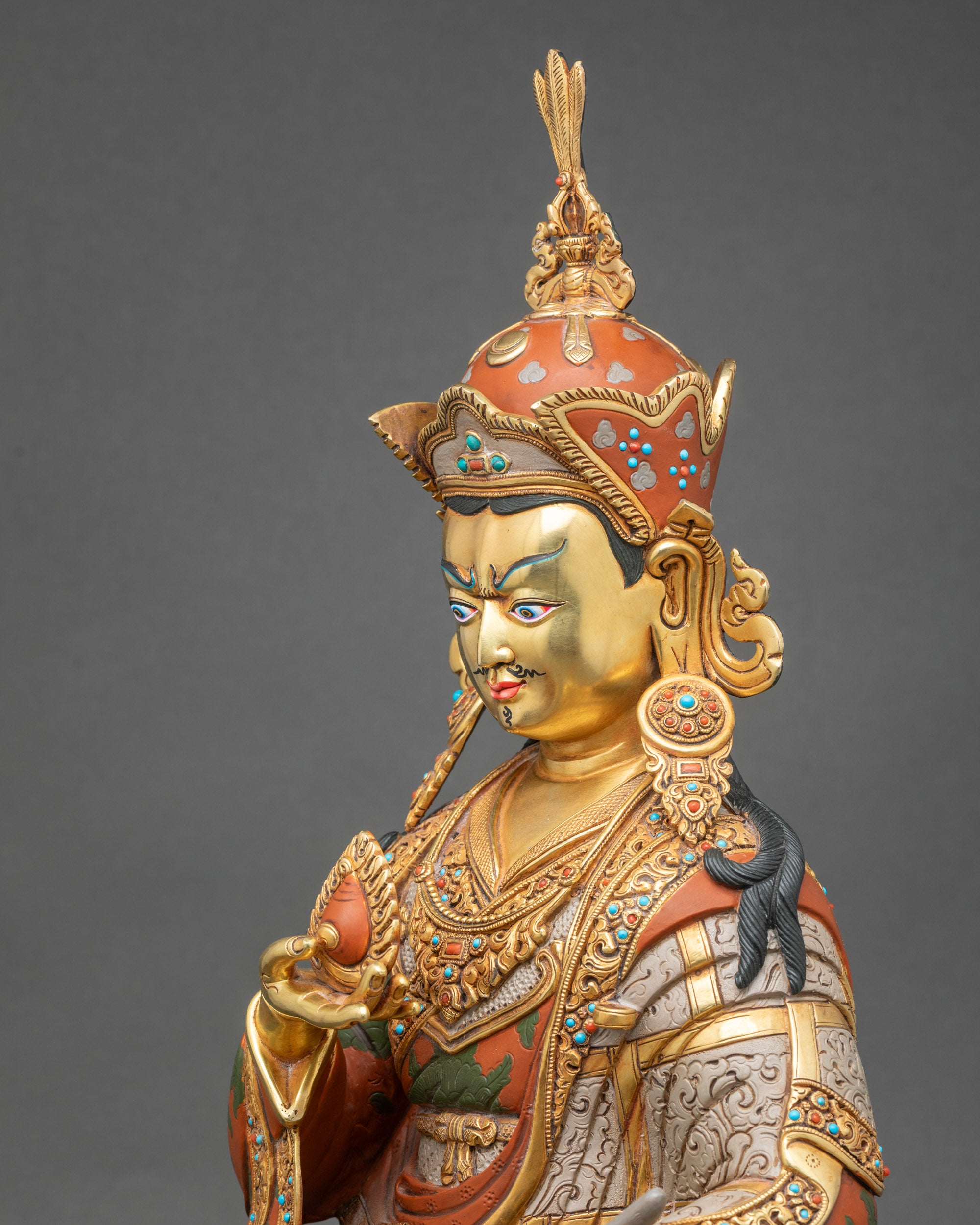 Detailed side close-up of Guru Norlha statue showing carved robes and ornate patterns