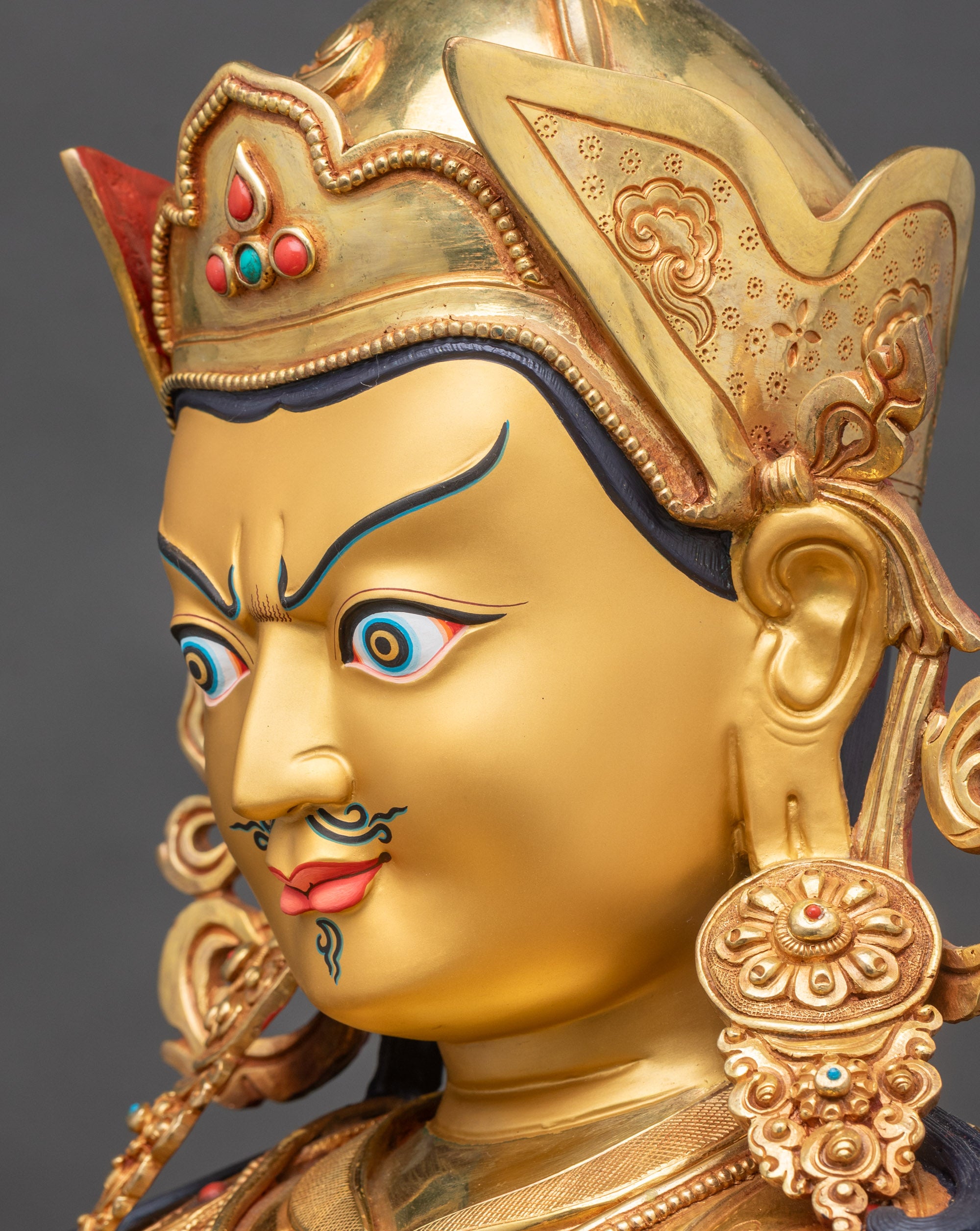 Detailed side close-up of Guru Rinpoche face, showing gold fire-gilded features and expression
