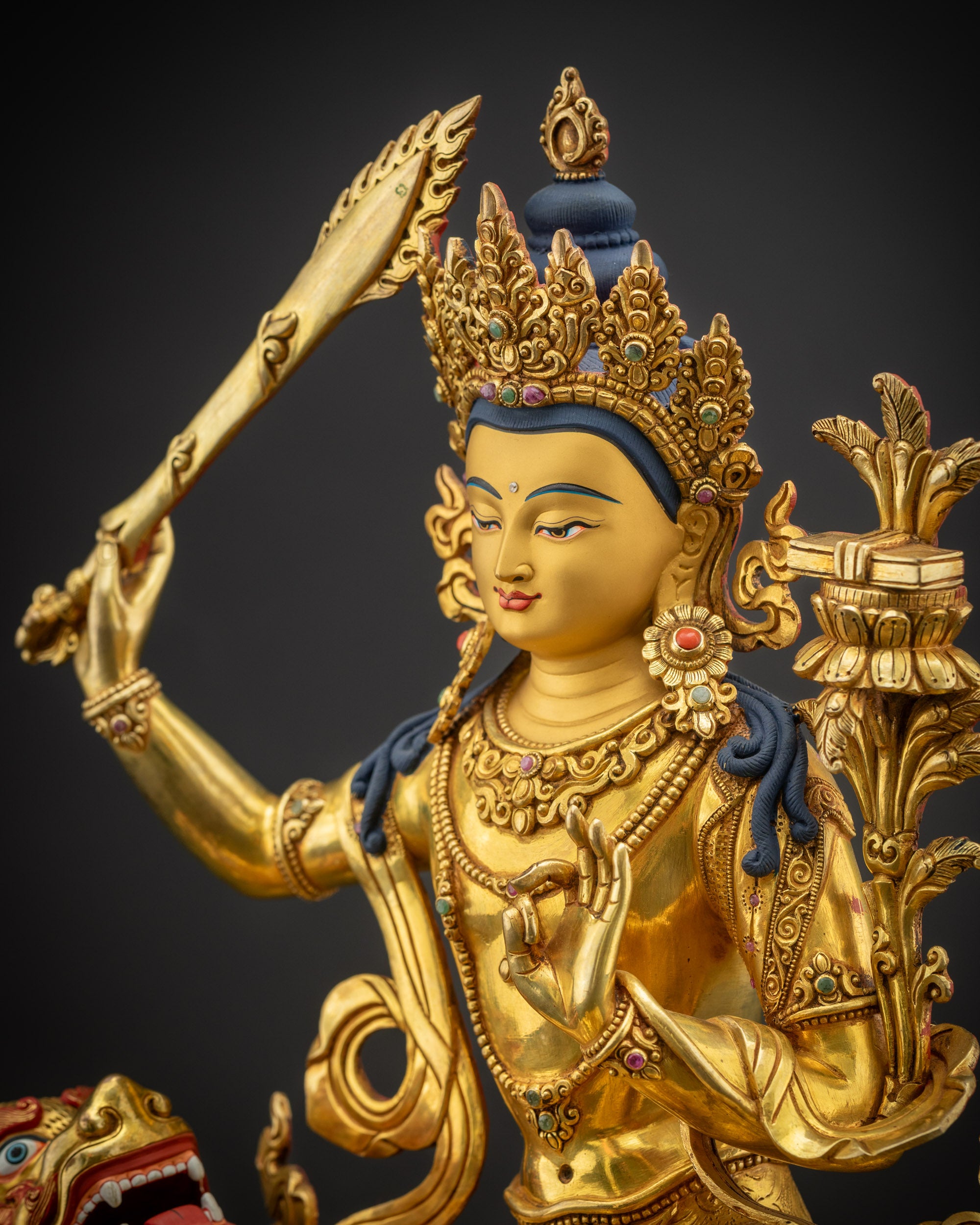 Detailed side close-up of Manjushri statue highlighting flaming sword and utpala flower details