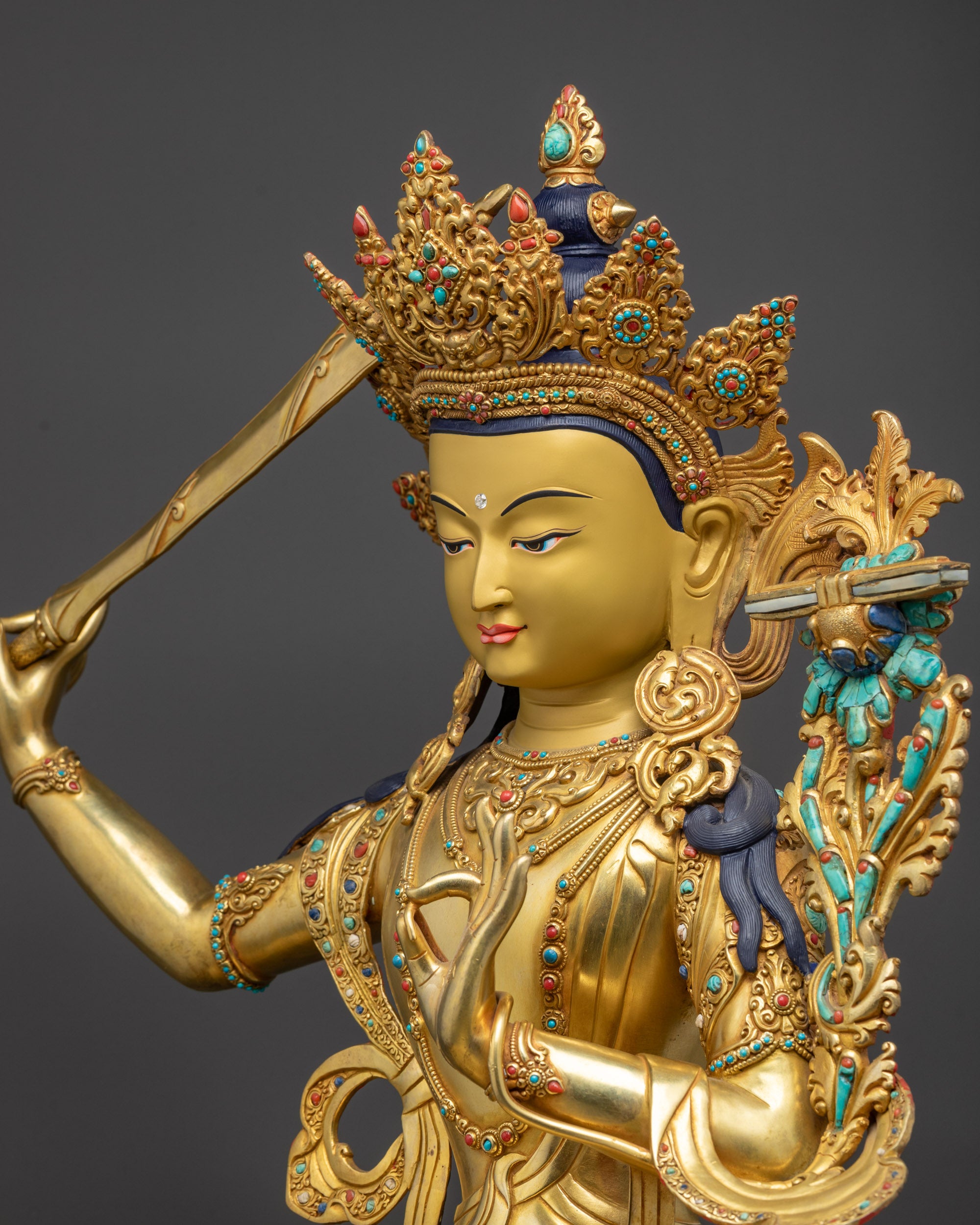 Detailed side close up Manjushri Sculpture showing flowing robes and sacred objects