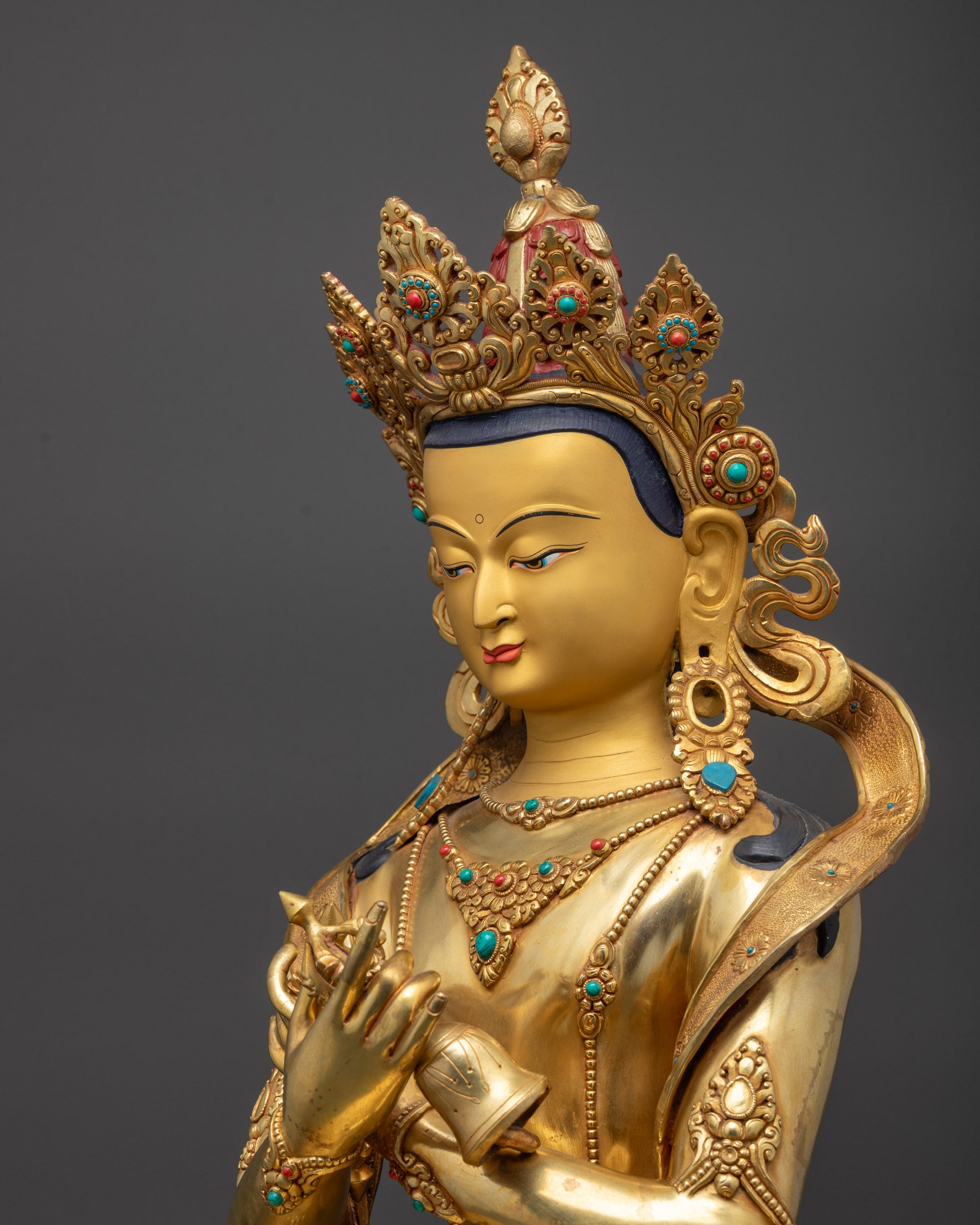 Detailed side close up Vajradhara statue capturing crossed-arm vajra and bell posture