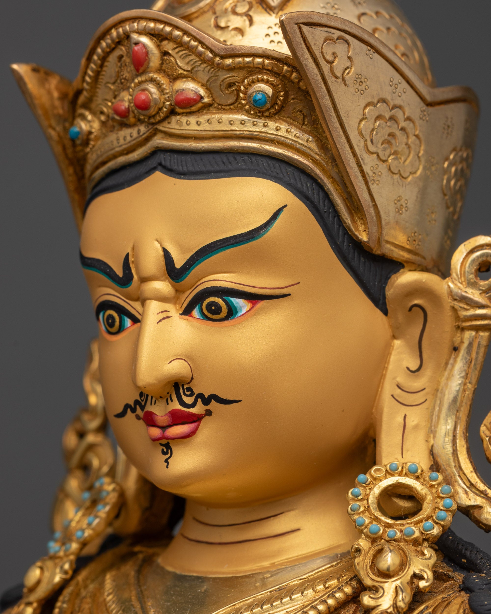 Detailed side close up face of Guru Rinpoche highlighting gold-gilded features