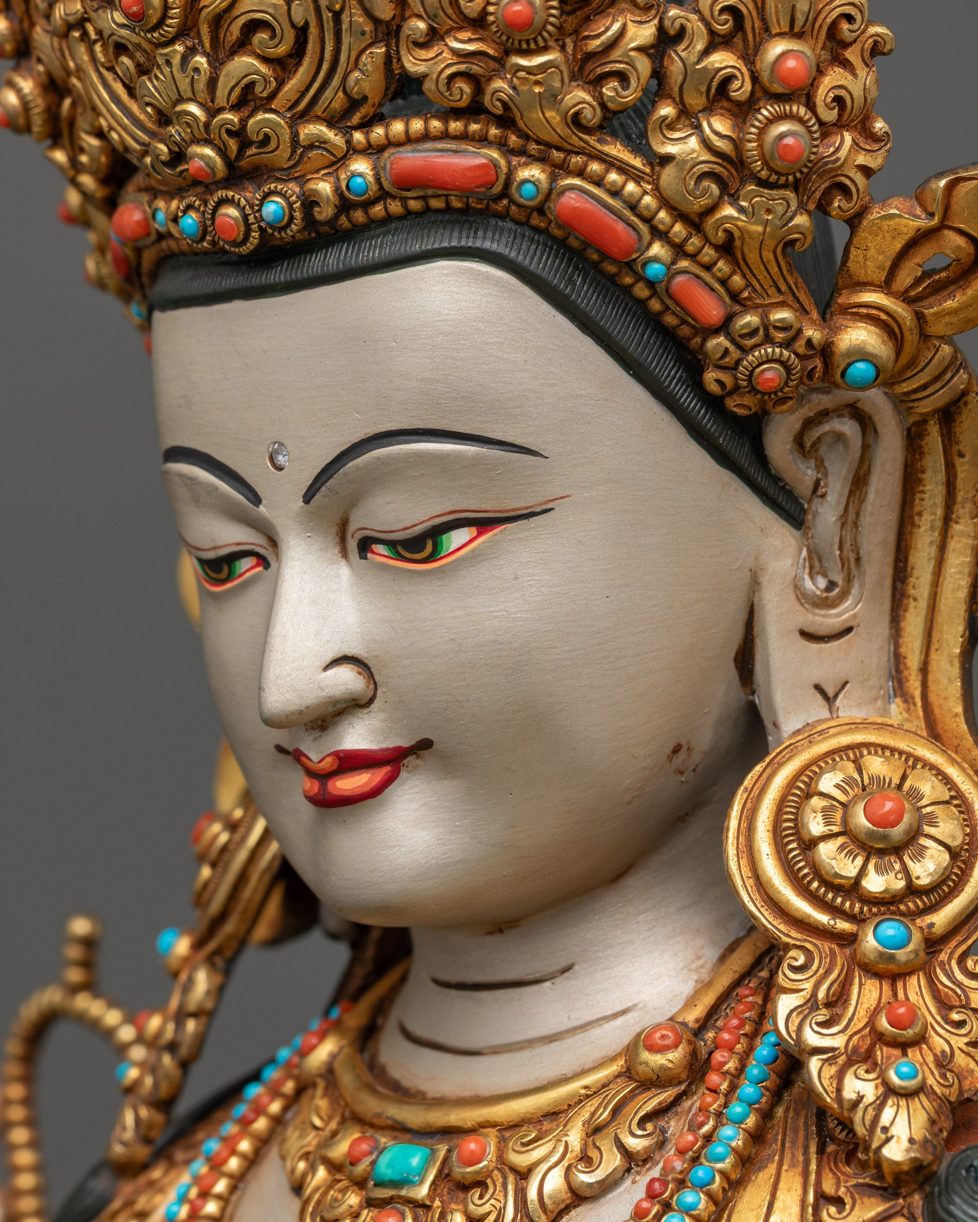 Detailed side close up of Chenrezig statue face showing serene compassionate expression