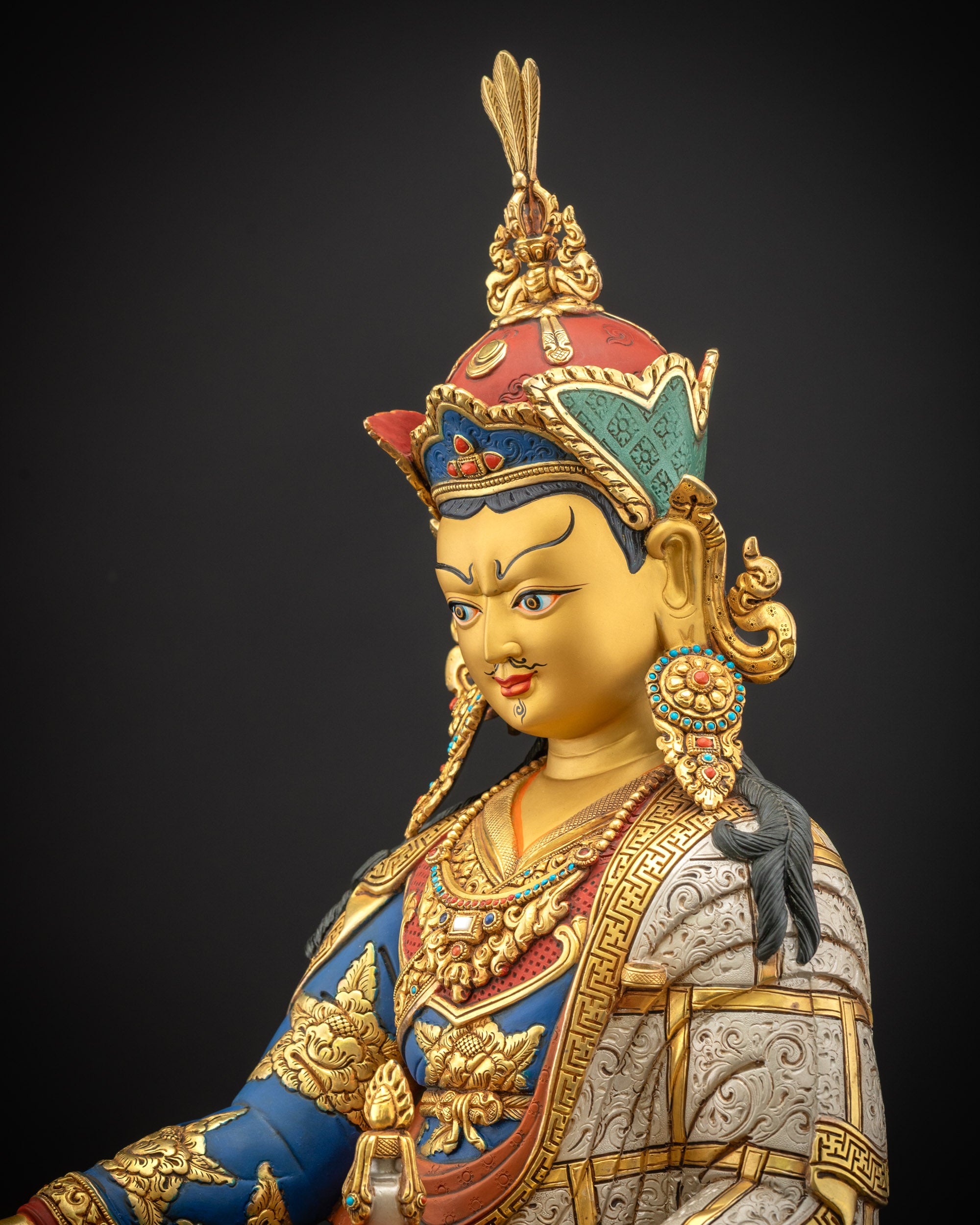 Detailed side close up of Guru Padmasambhava statue with royal layered monastic robes