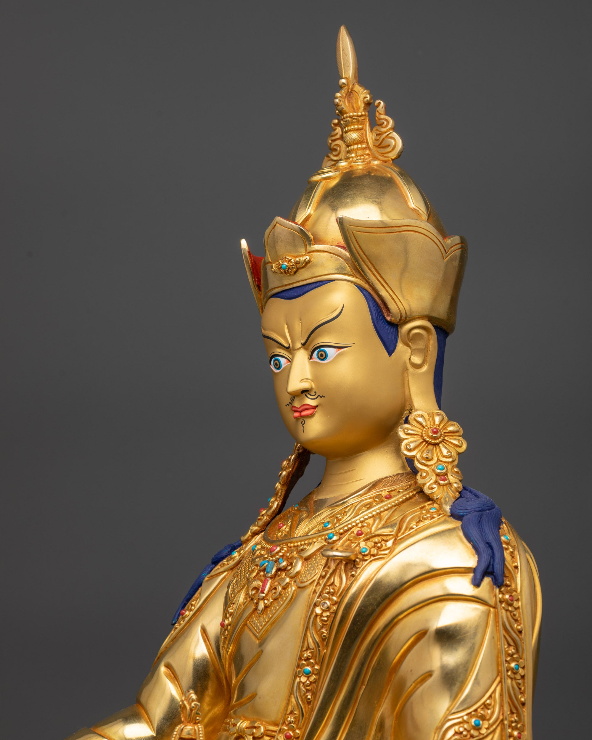 Detailed side close up of Guru Rinpoche statue highlighting kasaya robe patterns