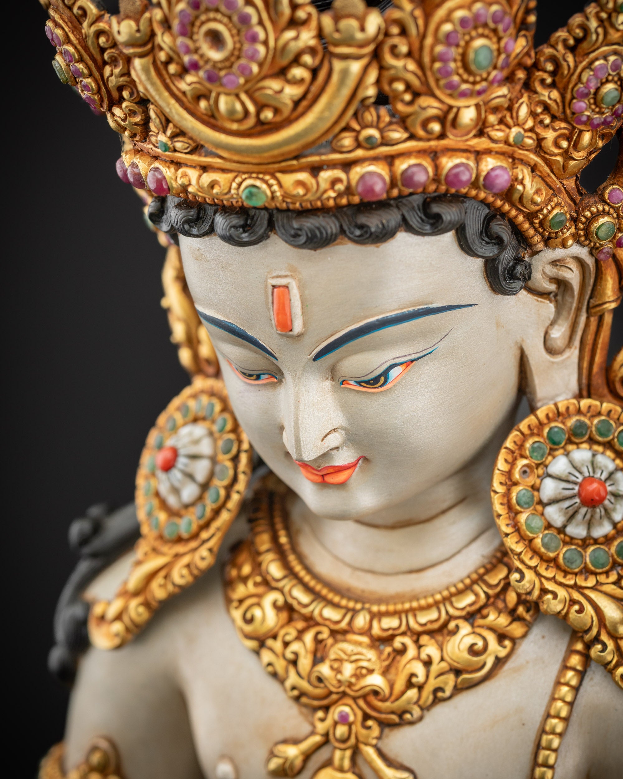 Detailed side close up of Lokeshvara statue showing crown and hand-carved lower garment