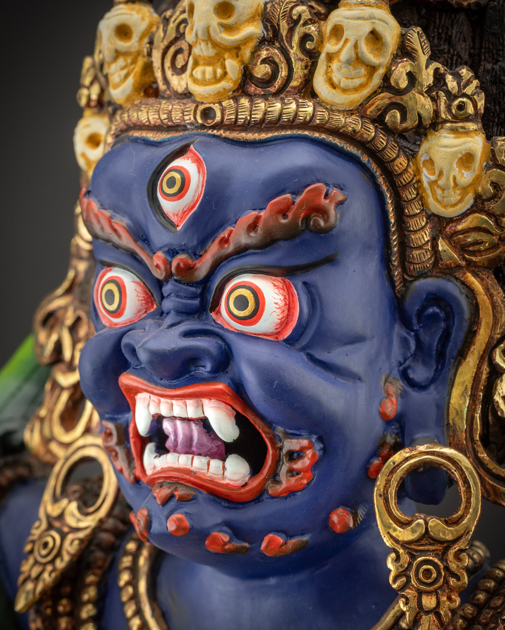Detailed side close up of Vajrapani face with earrings and skull crown