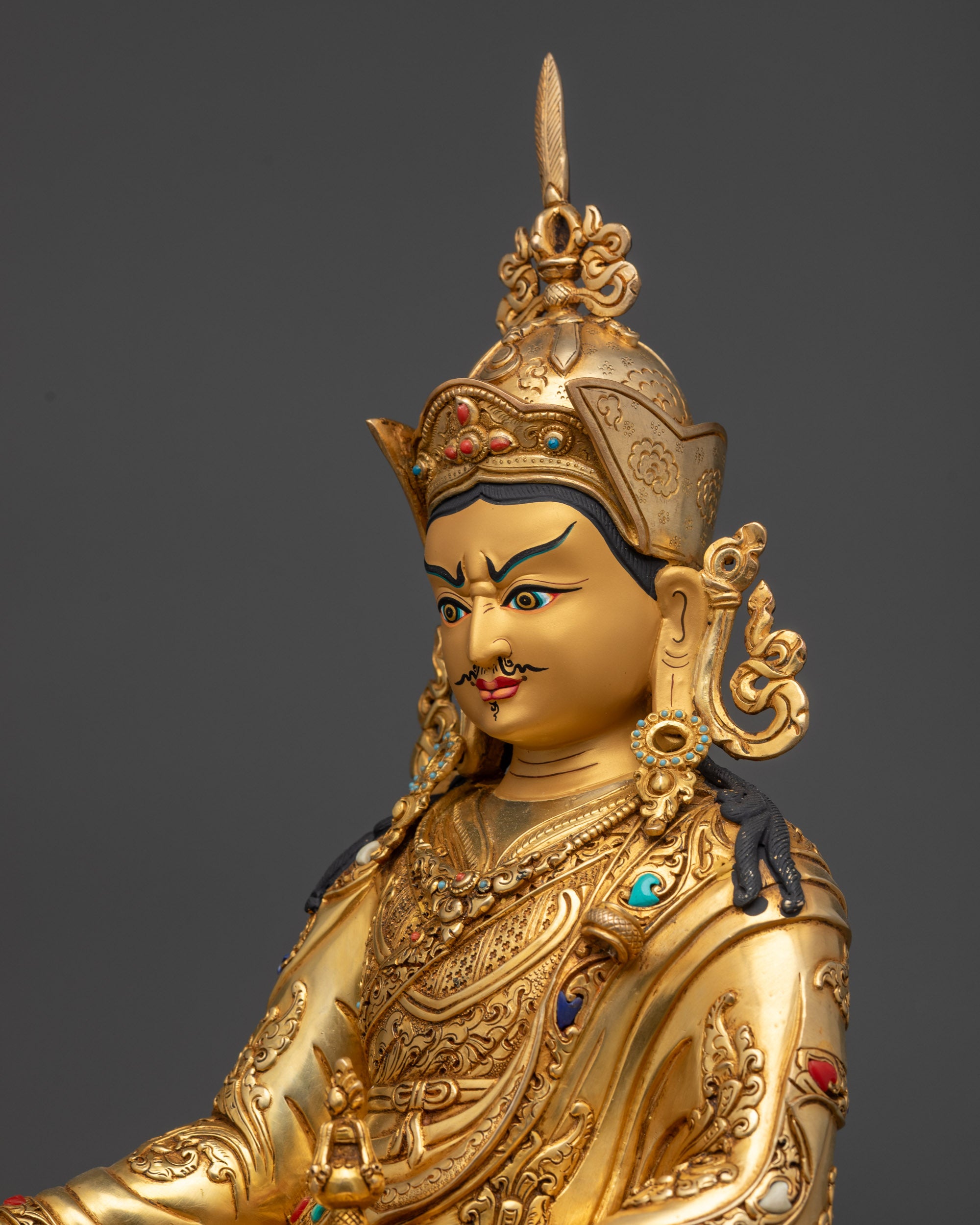 Detailed side close up of enthroned Guru Padmasambhava with intricate garments
