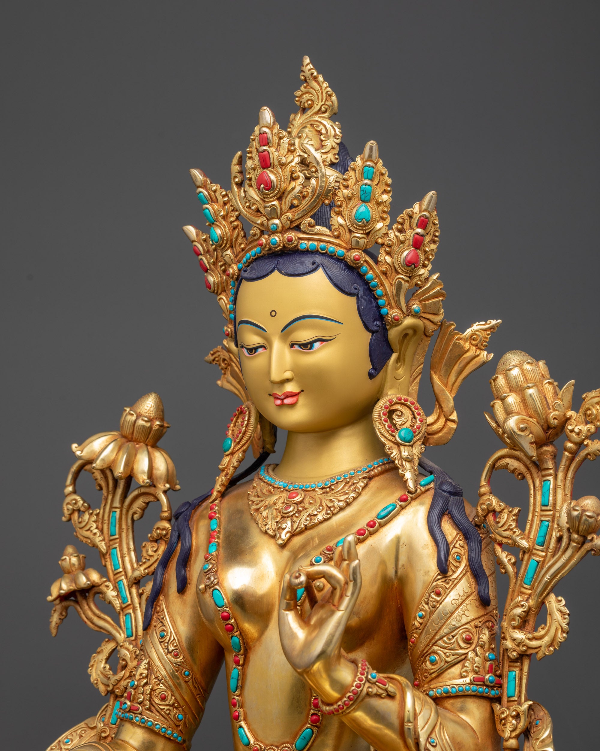 Detailed side view Green Tara statue gold-gilded with intricate jewelry and robe patterns