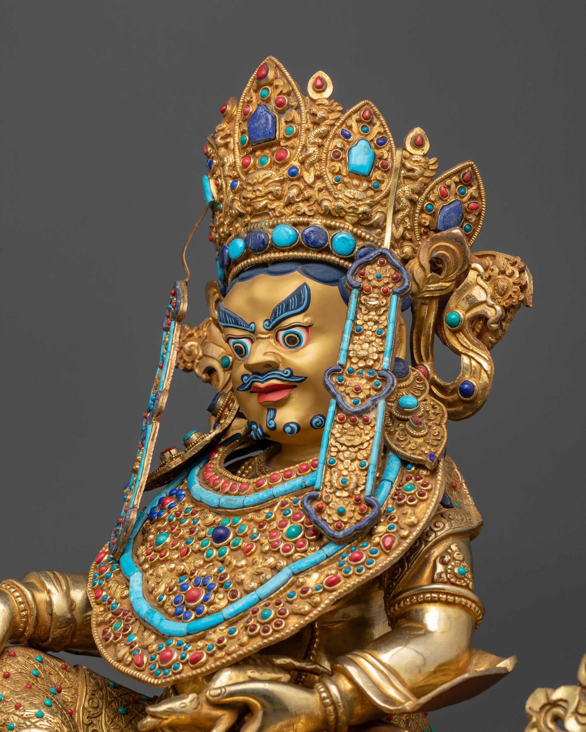 Detailed side view of Dzambhala statue displaying lotus pedestal, robes, and intricate carvings