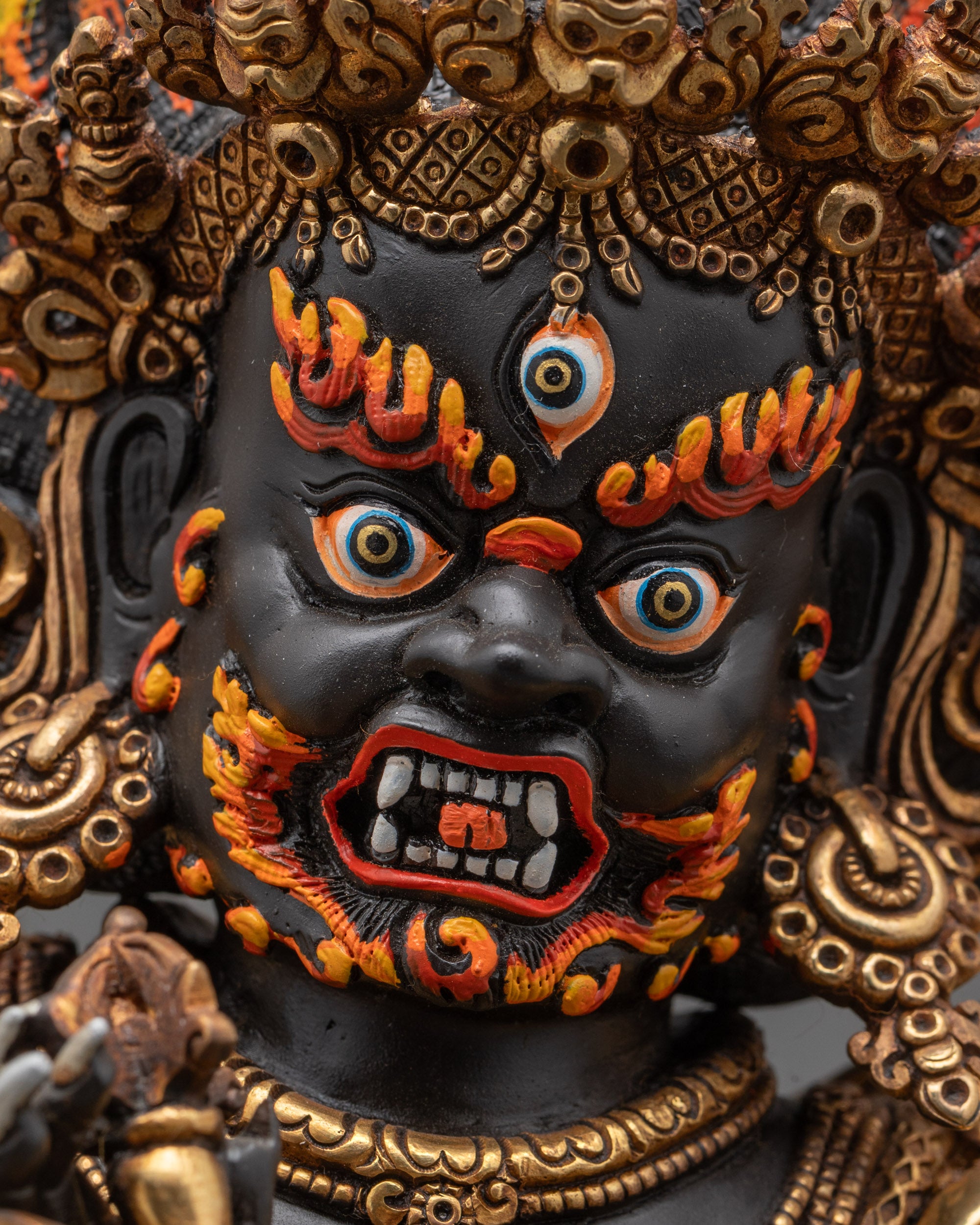 Detailed upper close up of Mahakala face with third eye, fangs, and red eyebrows
