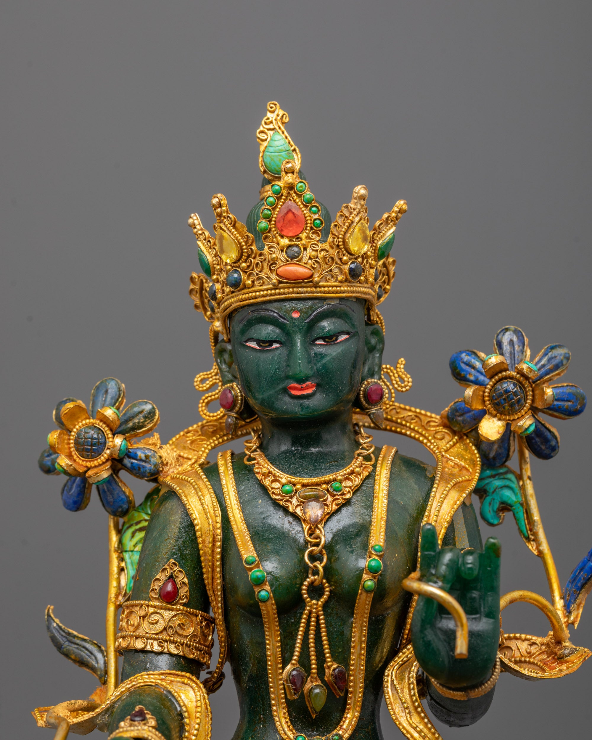 Detailed view of Green Tara's serene jade face and ornate crown