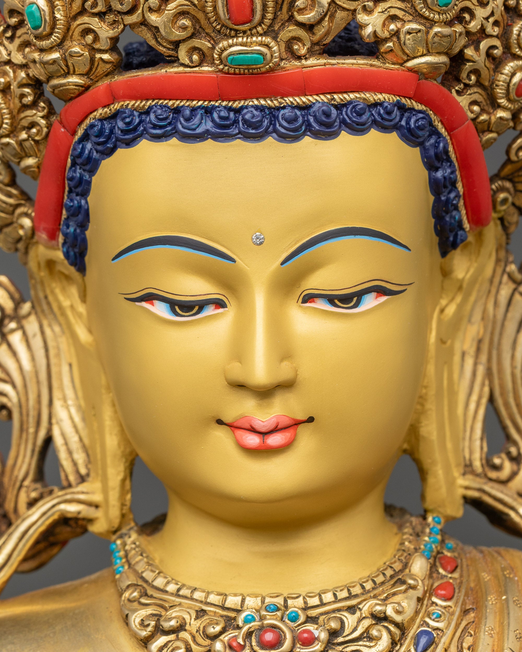 Detailed view of Mitrugpa Buddhaβs tranquil gold-painted face highlighting meditation expression.