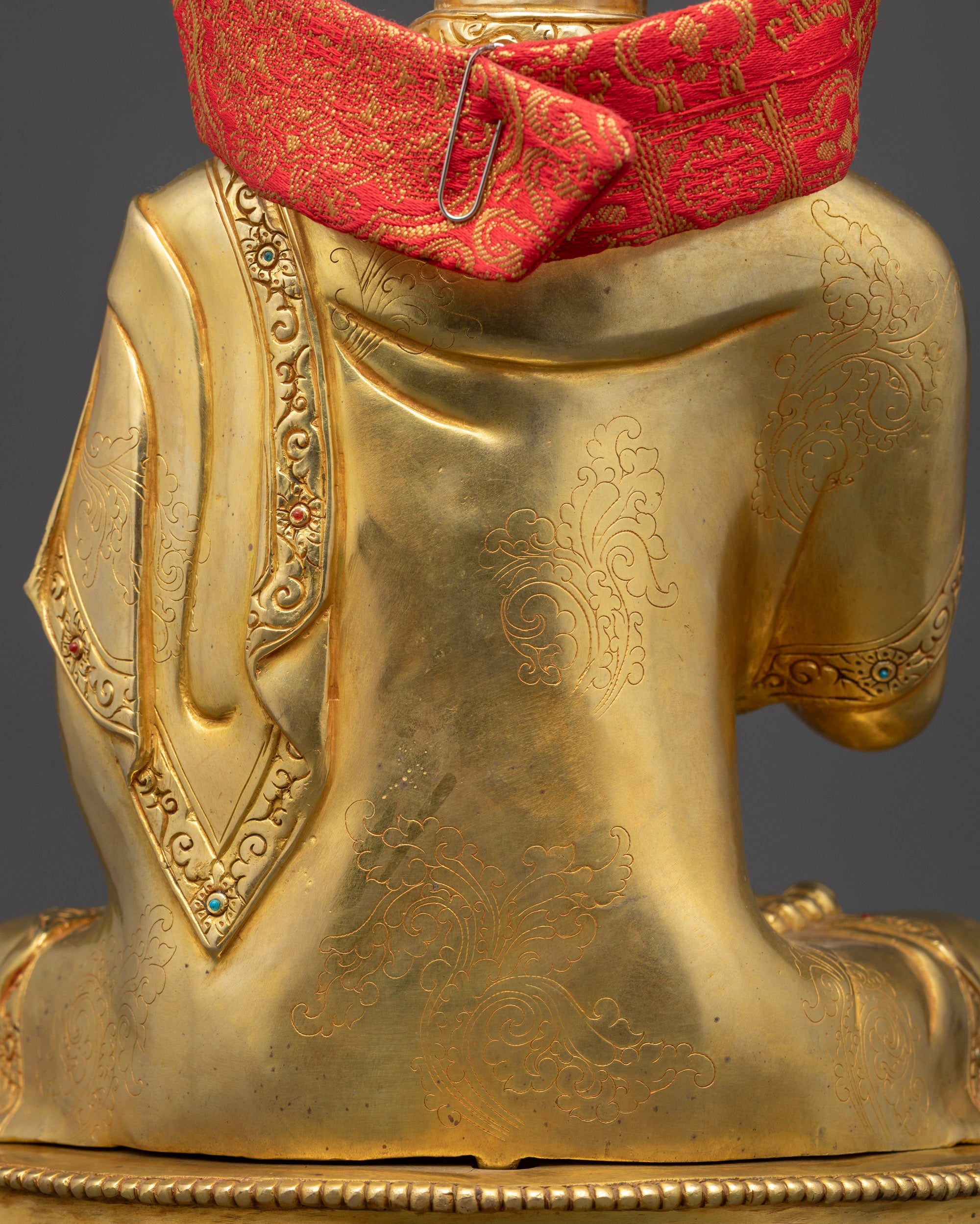 Detailed view of Tsongkhapa's monastic robes, highlighting folds and patterns on the gold-gilded body.