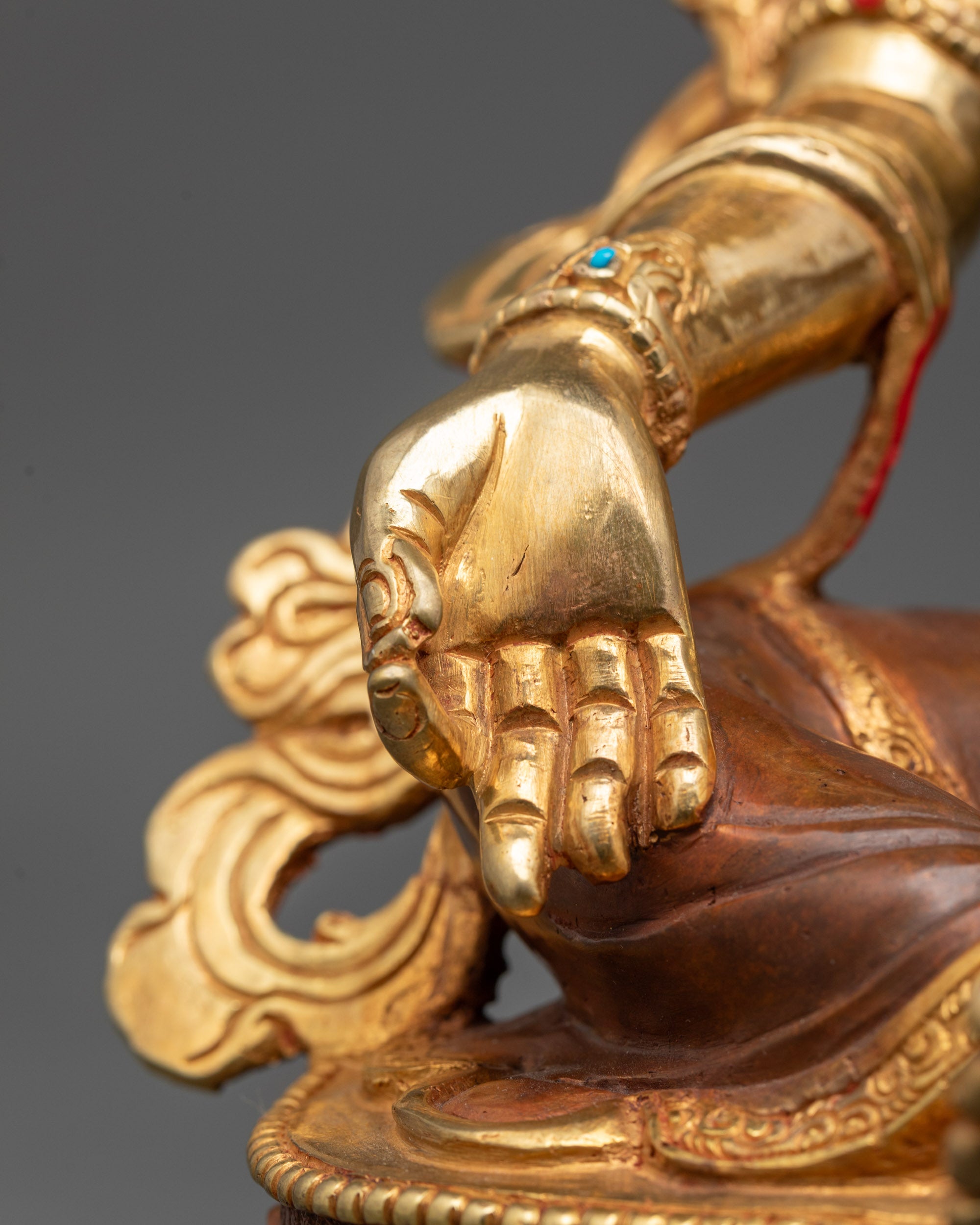 Detailed view of Utpala flower and Vitarka mudra hand gesture on Green Tara statue