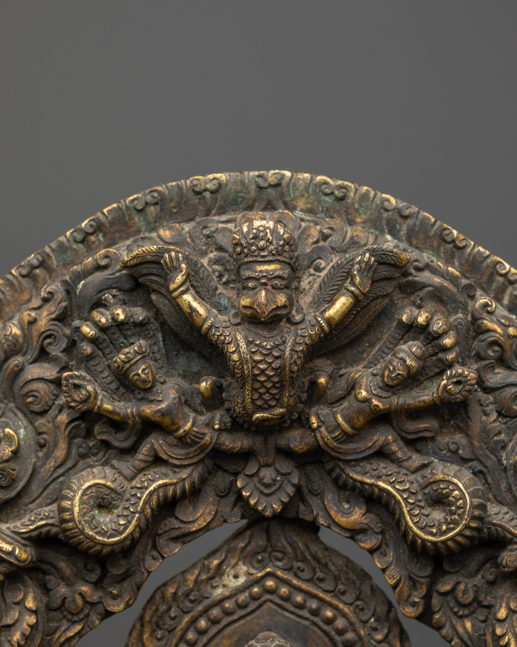 Detailed view of the antique Buddha's halo, featuring finely carved deities, patterns, and a kalash finial.