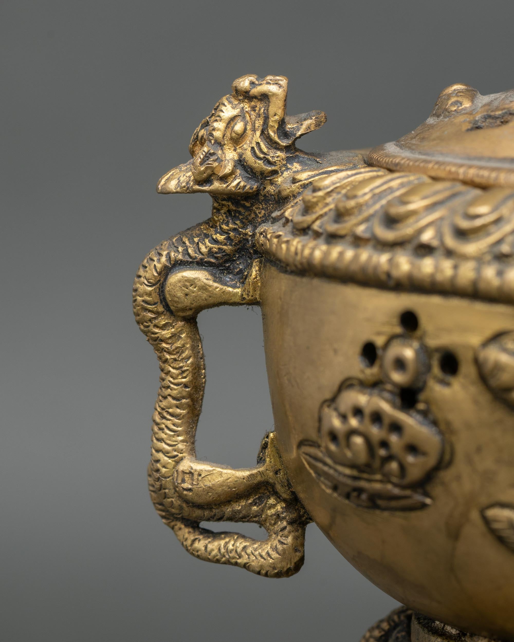Dragon handle detail on hand-carved brass Buddhist incense burner made in Nepal