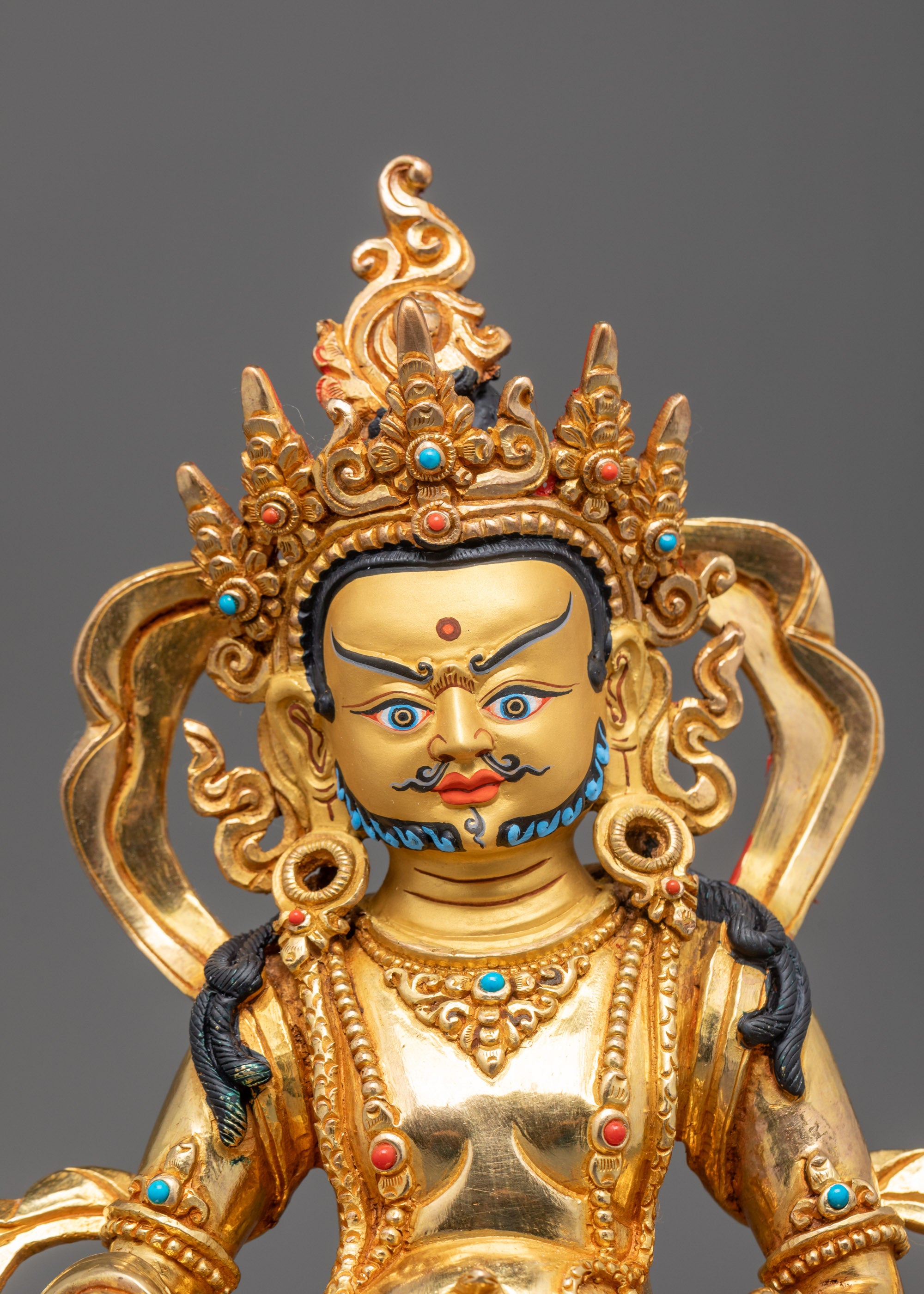 Close-up of Dzambhala Statue crown, jewel-spitting mongoose, and semi-precious stones