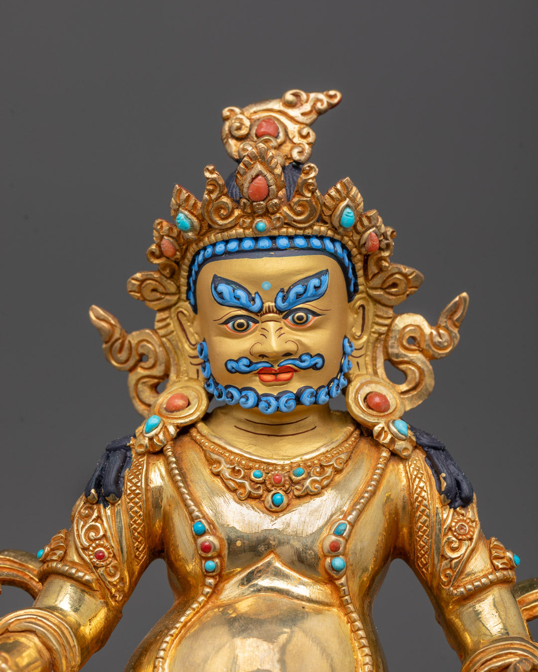 Close-up of Dzambhala’s face and intricate details of 24k gold gilded copper