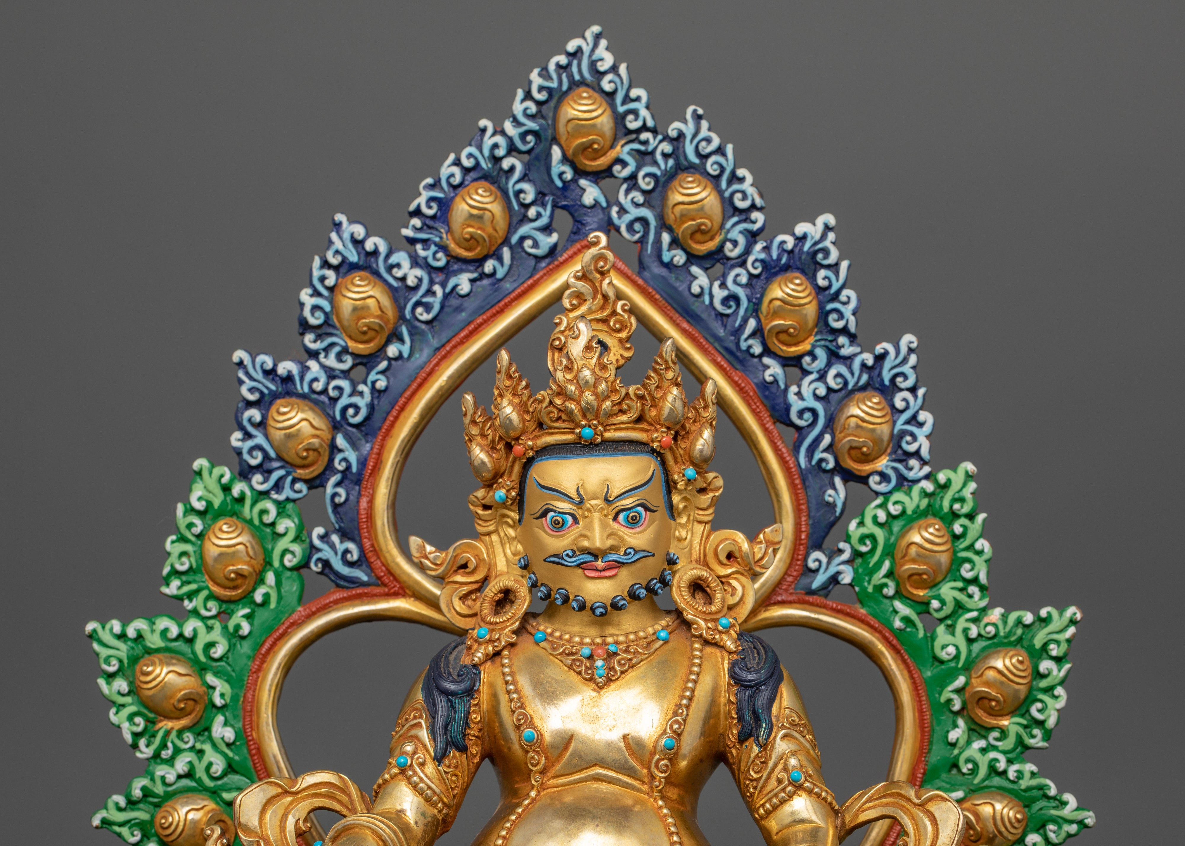 view of Dzambhala’s upper side, emphasizing the detailing on the ornate crown, facial features and colorful halo.