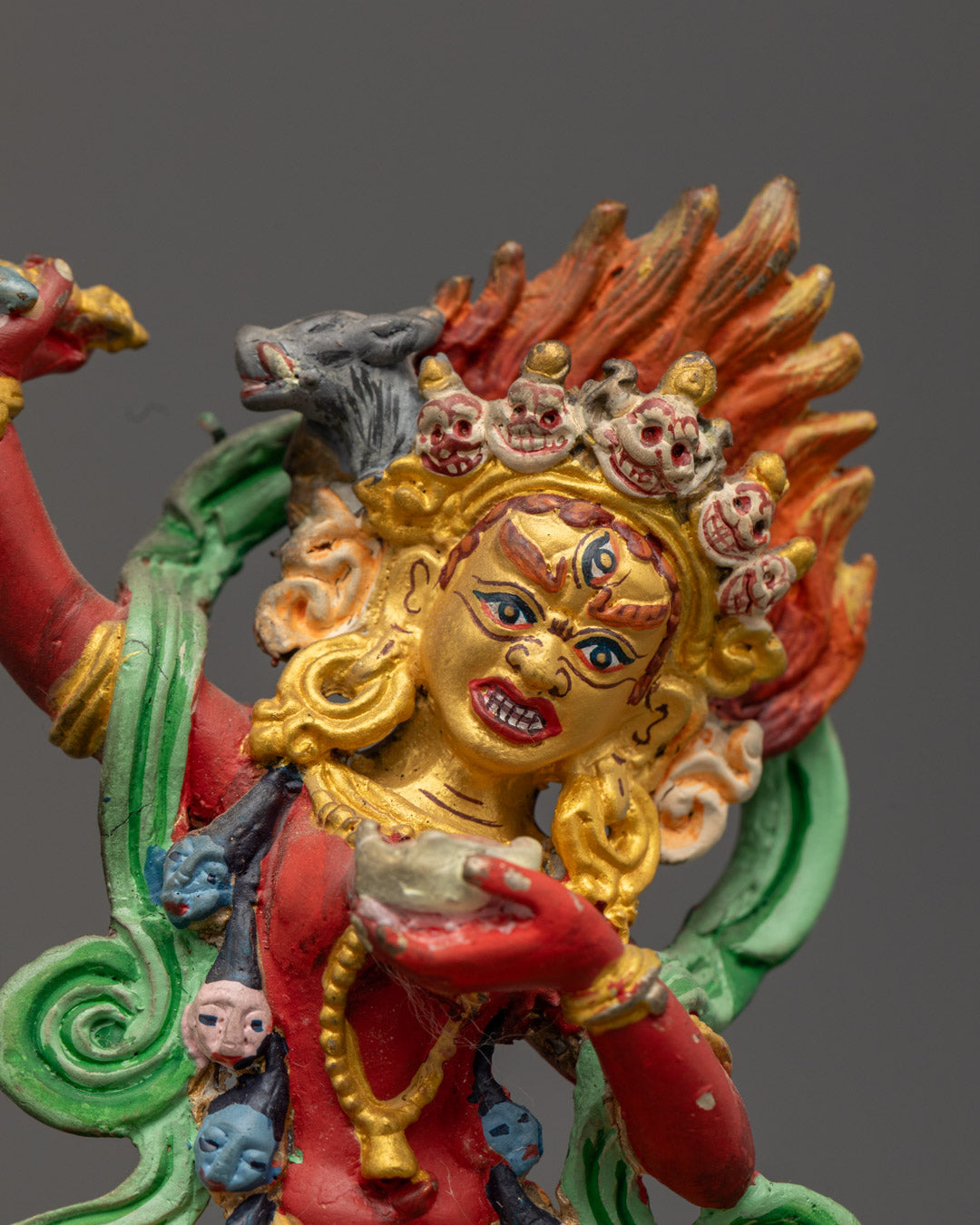 Expressive close-up of Dorje Phagmo's wrathful yet compassionate face, hand-painted with red and gold tones.