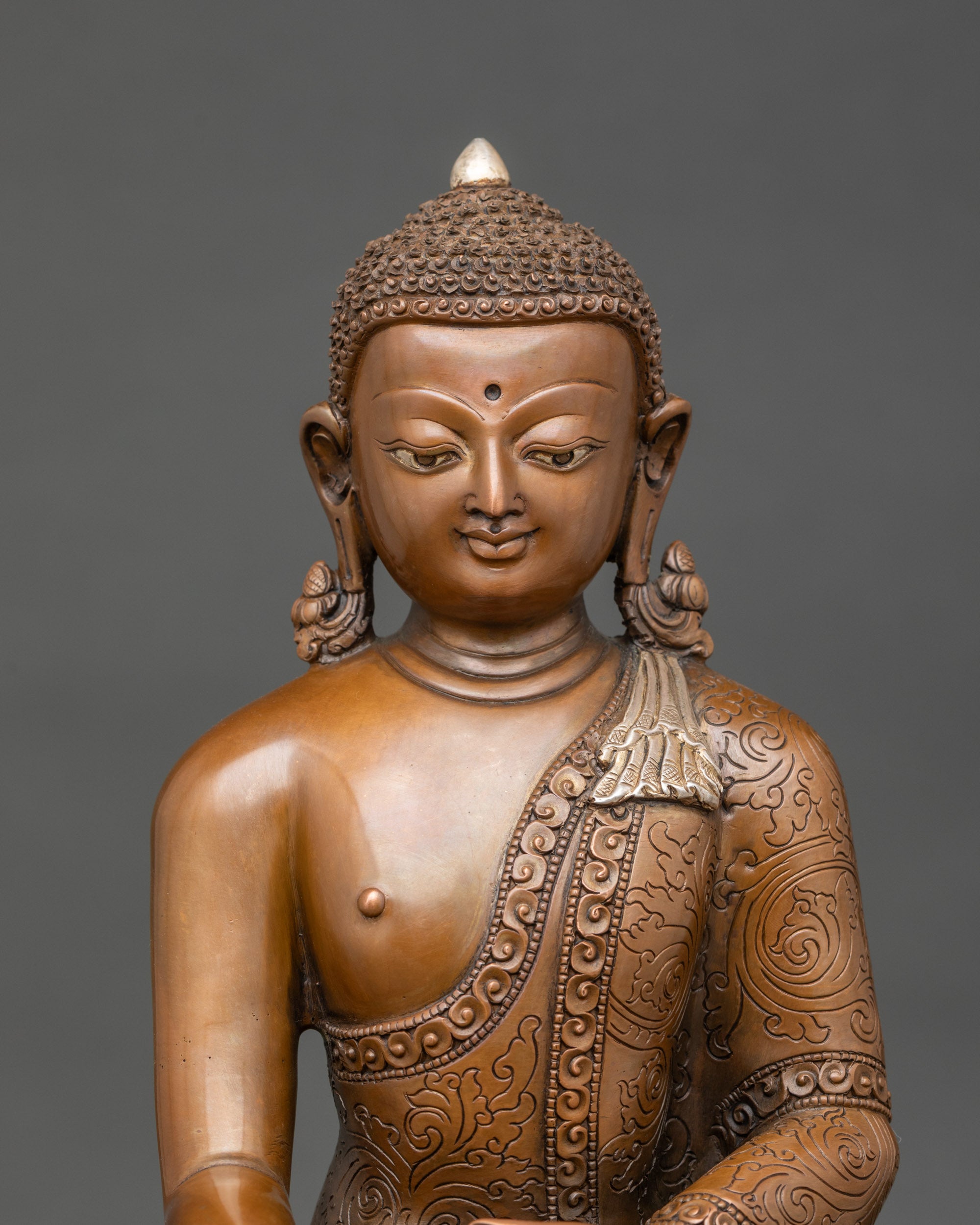 Close-up of Buddha's serene face with gold highlights and oxidized copper finish