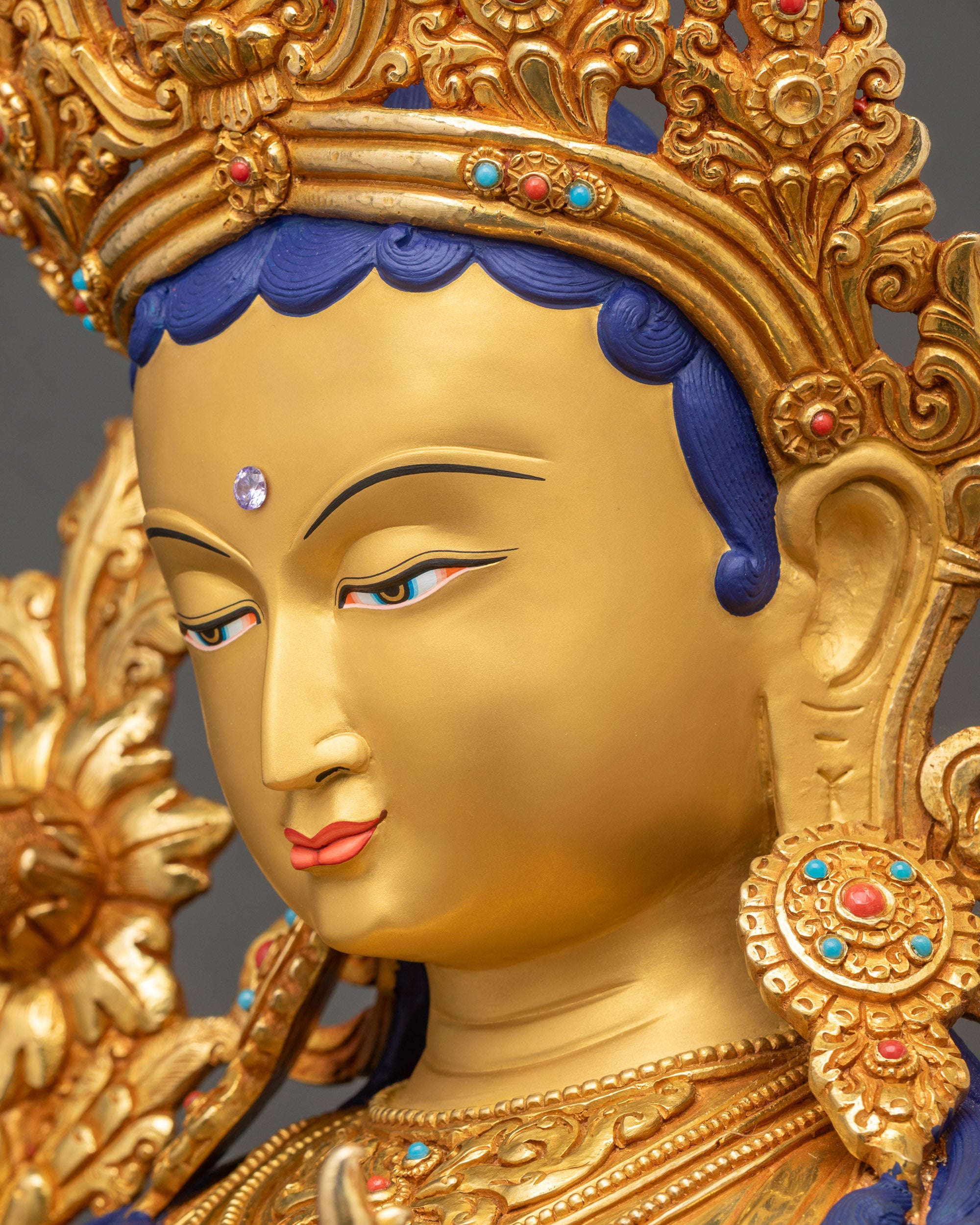 Green Tara statue side face close up with refined facial features and gilded finish