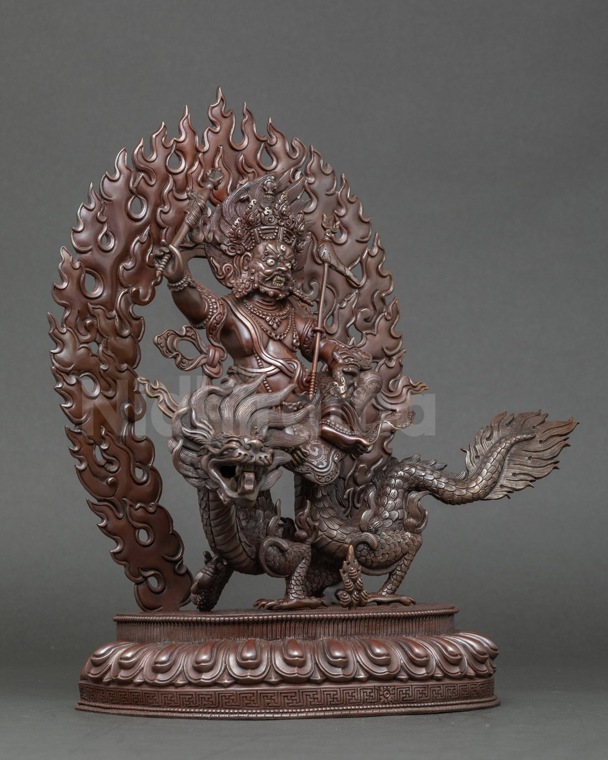 Side view White Dzambhala sculpture, seated on lotus base atop legendary dragon