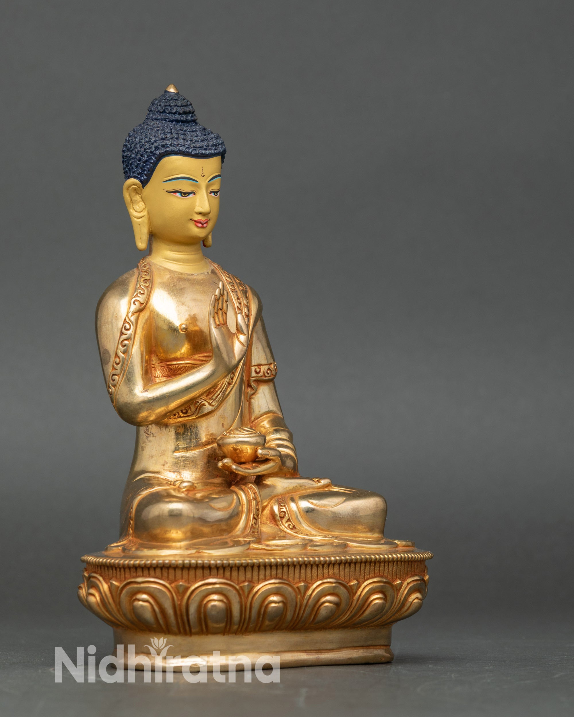 Side view Amoghasiddhi statue seated on moon disc and lotus, symbol of fearlessness and wisdom