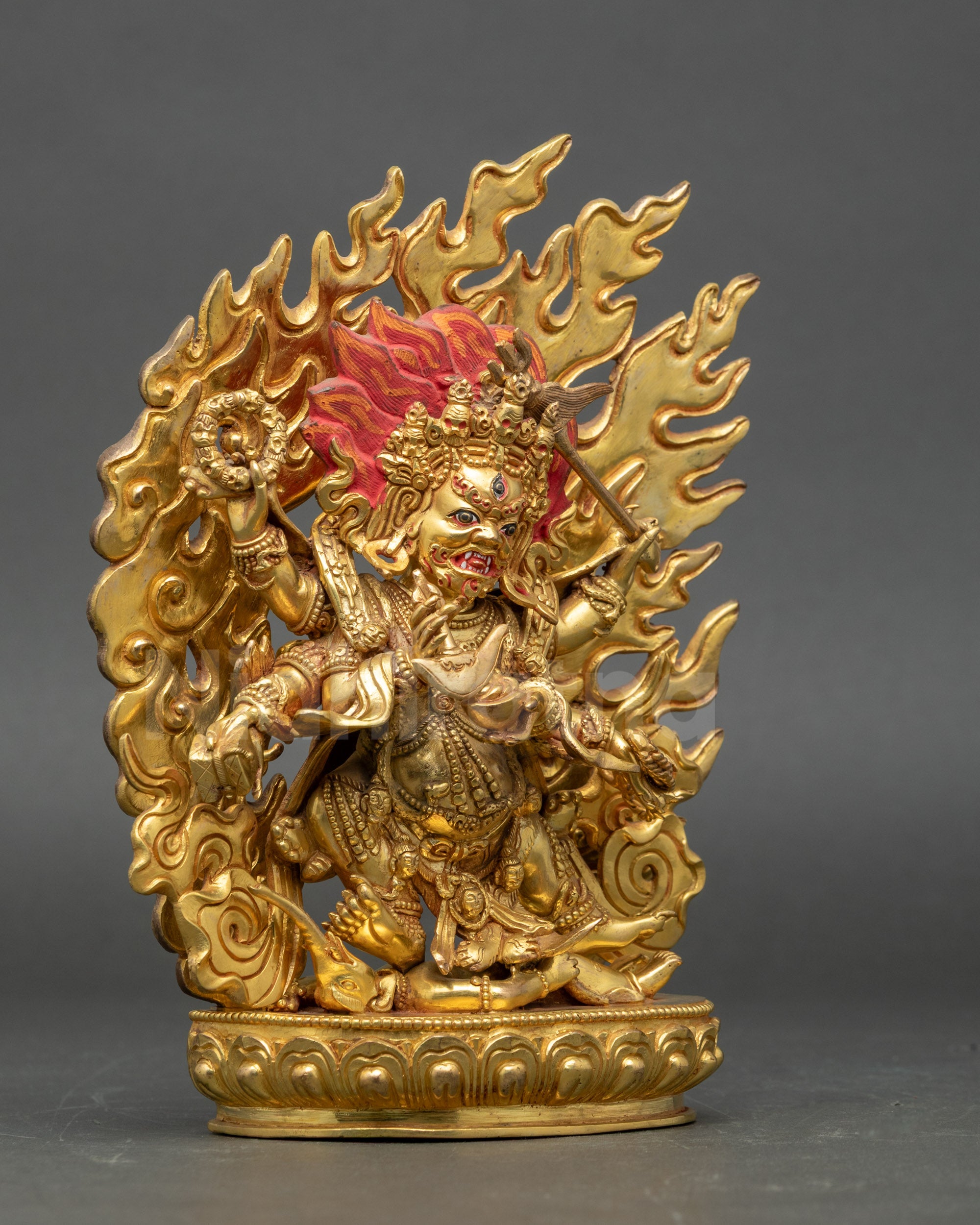 Side view Mahakala statue holding damaru and trident, Vajrayana protector sculpture