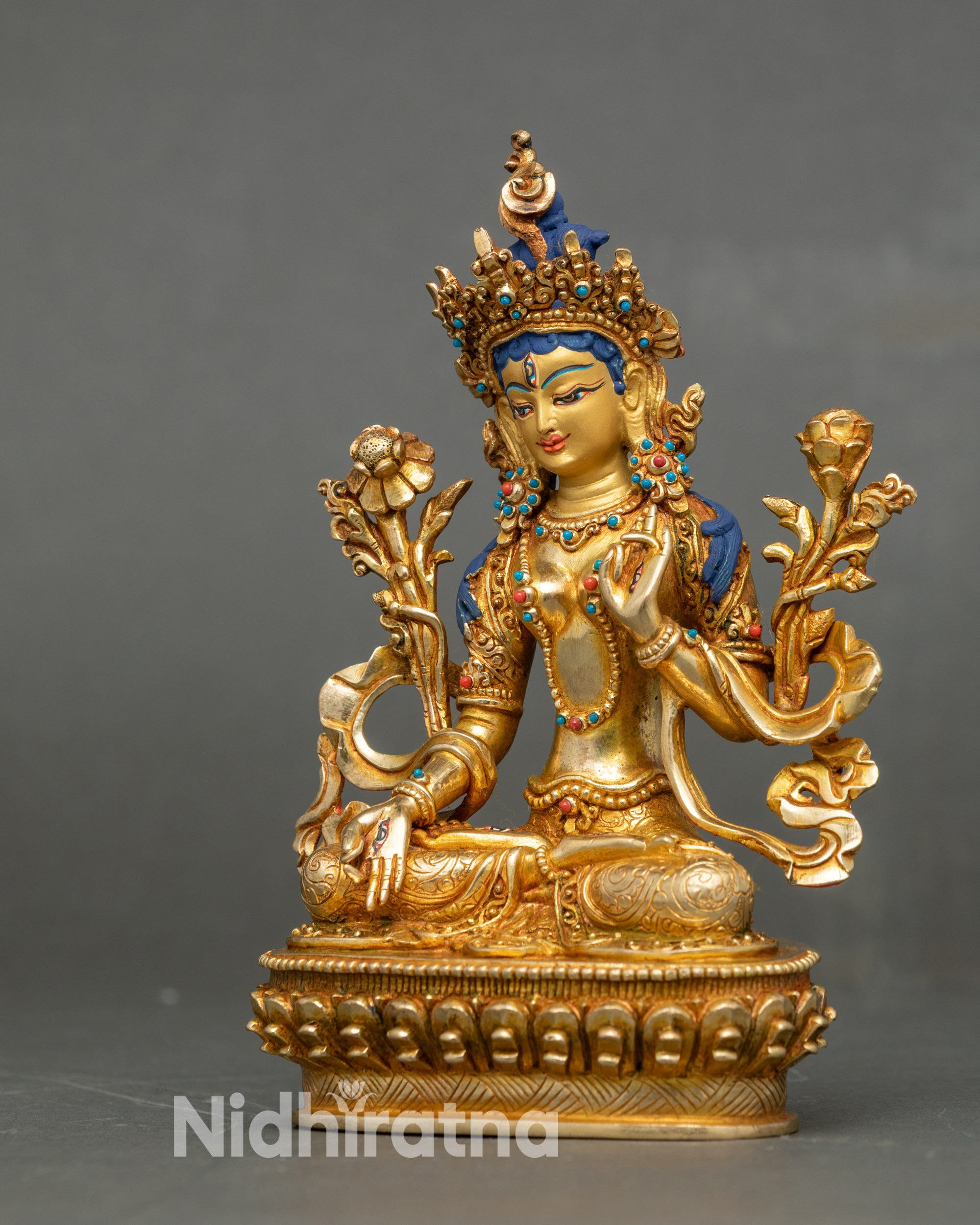 Left profile of White Tara seated on lotus, displaying hand mudras and flower